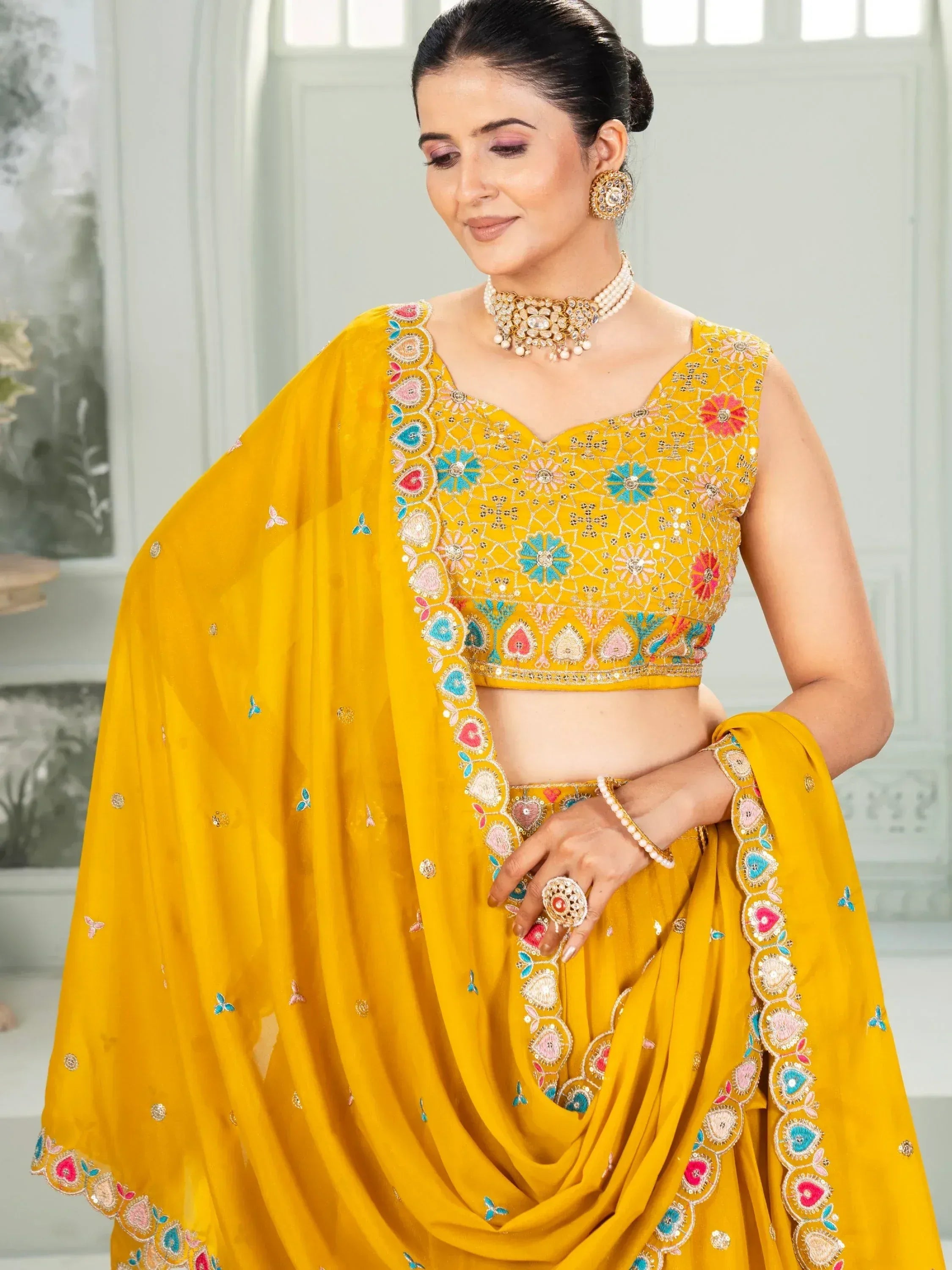 Yellow embroidered lehenga choli with floral motifs, perfect for Indian ethnic wear and festive occasions.