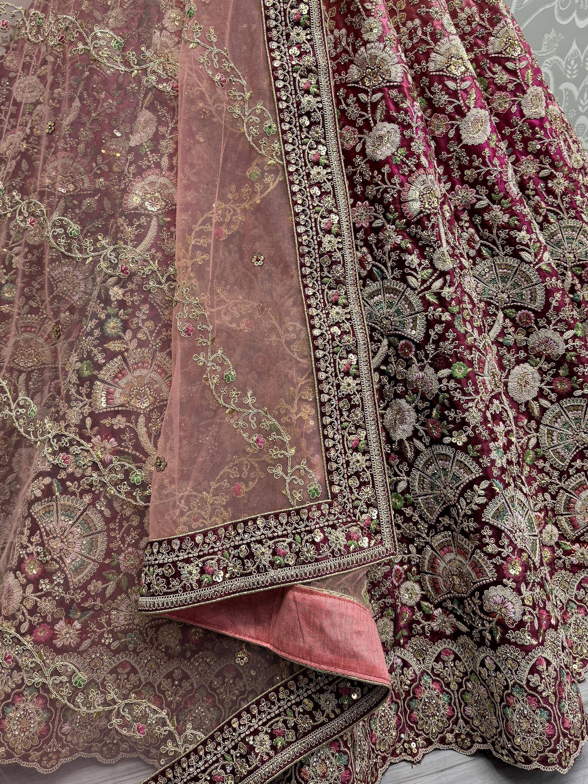 Luxury maroon lehenga choli with intricate gold embroidery and floral motifs, perfect for Indian weddings.