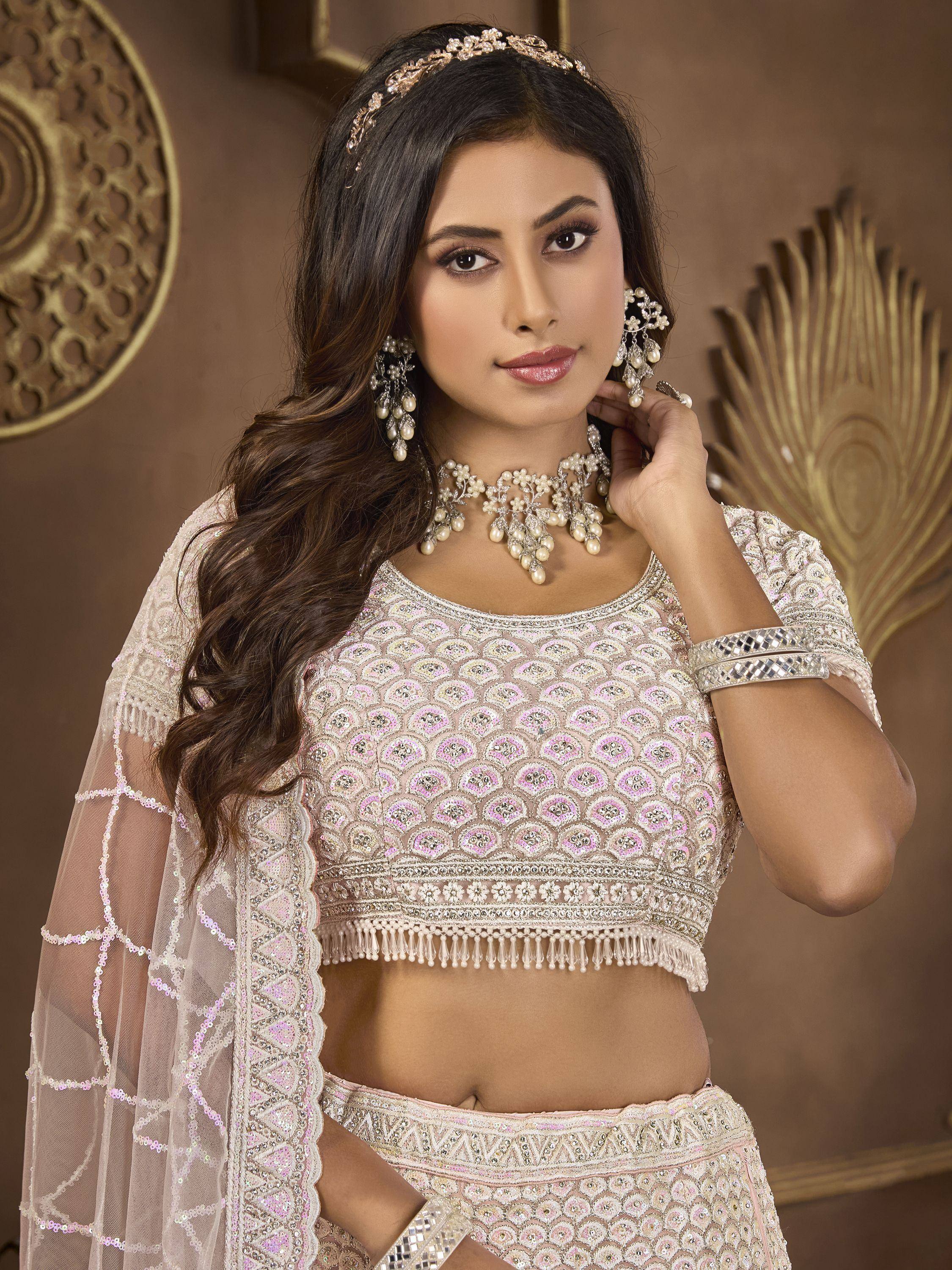 Elegant Indian lehenga choli with intricate embroidery, pearl jewelry, and sheer dupatta for festive occasions