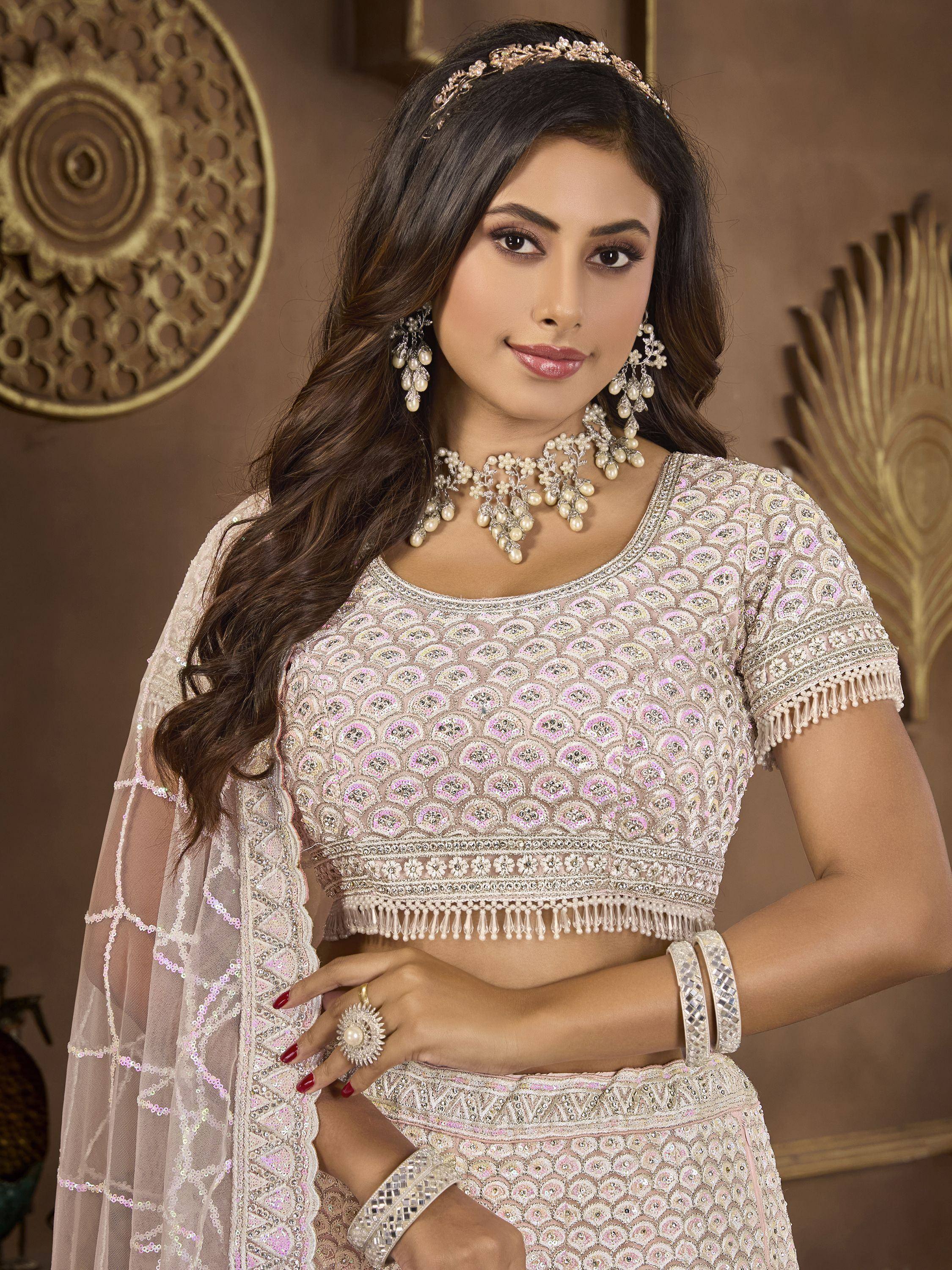 Elegant Indian lehenga choli with intricate embroidery, pearl jewelry, and sheer dupatta for festive occasions