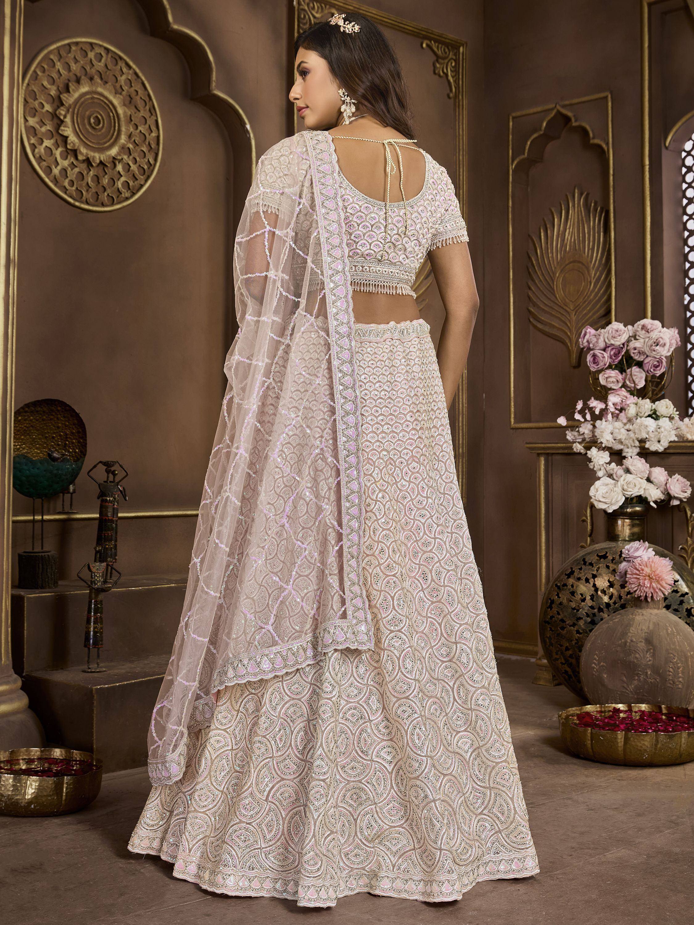 Elegant ivory lehenga choli with intricate embroidery and sheer dupatta, perfect for Indian weddings and festive occasions.