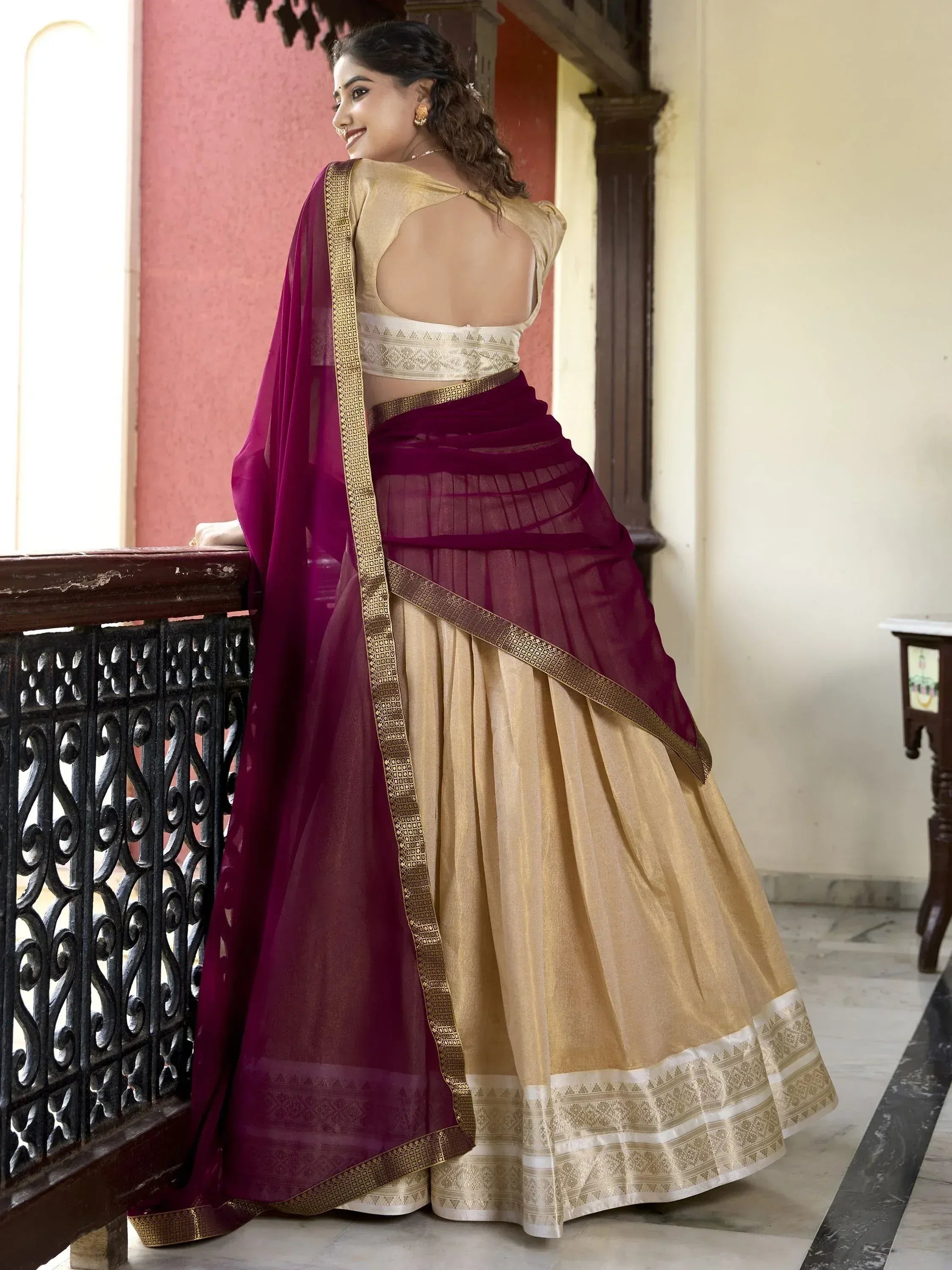 Woman in elegant maroon and gold lehenga choli with backless blouse, perfect for Indian ethnic occasions