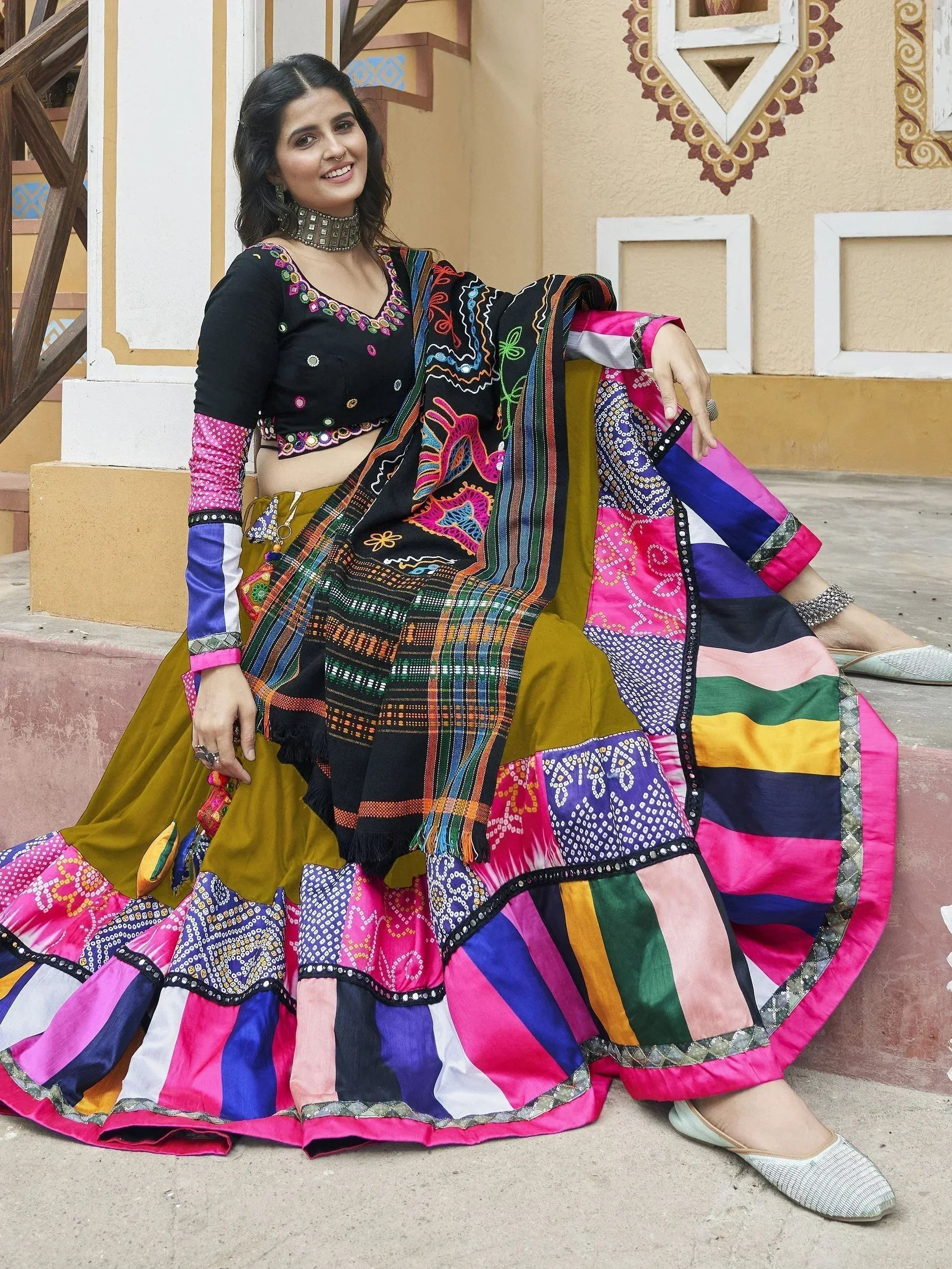 Colorful Indian ethnic lehenga choli with mirror work, patchwork skirt, and embroidered dupatta for festive occasions.