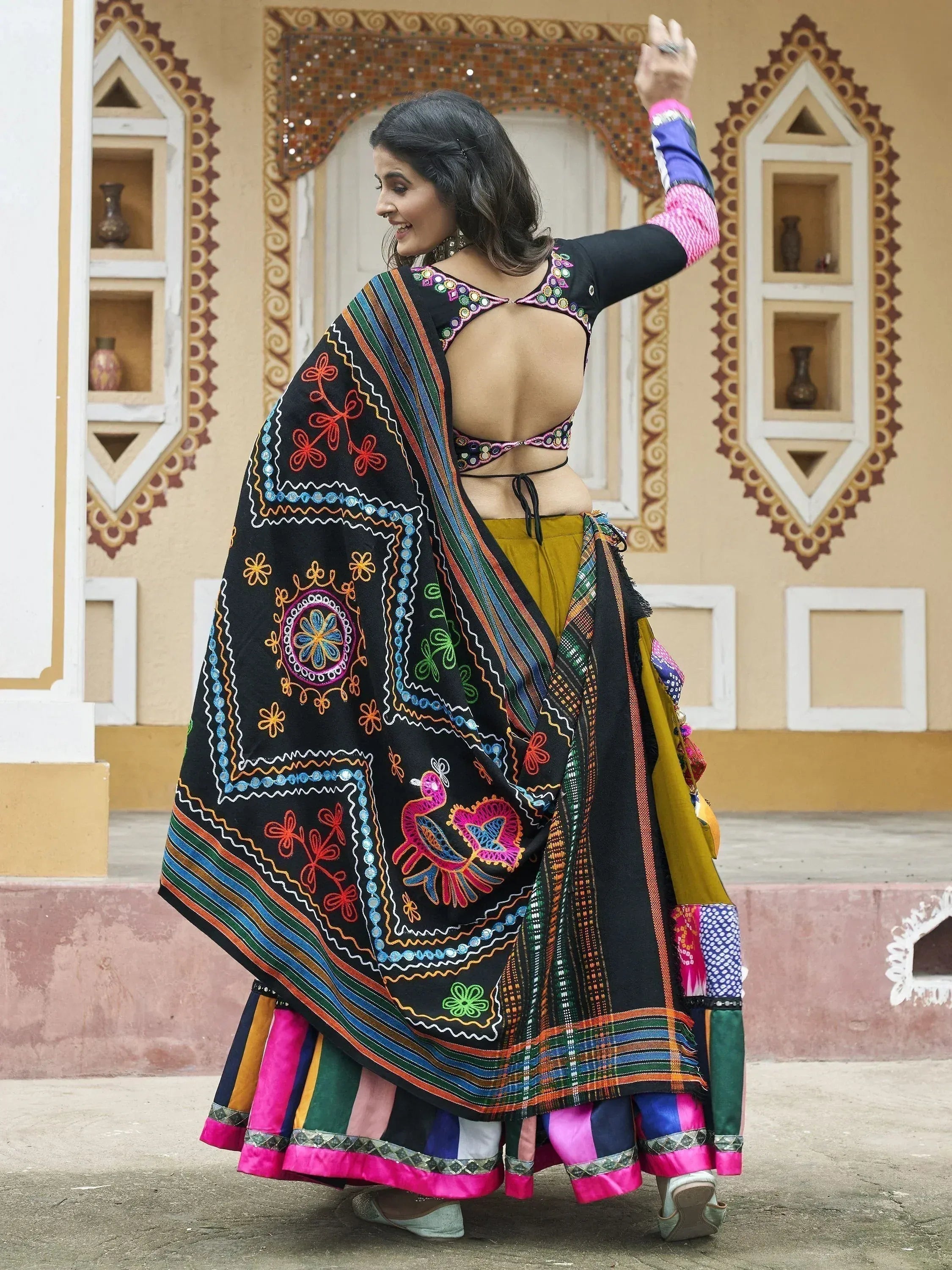 Woman in colorful embroidered Indian ethnic wear with backless blouse and dupatta, traditional festive attire