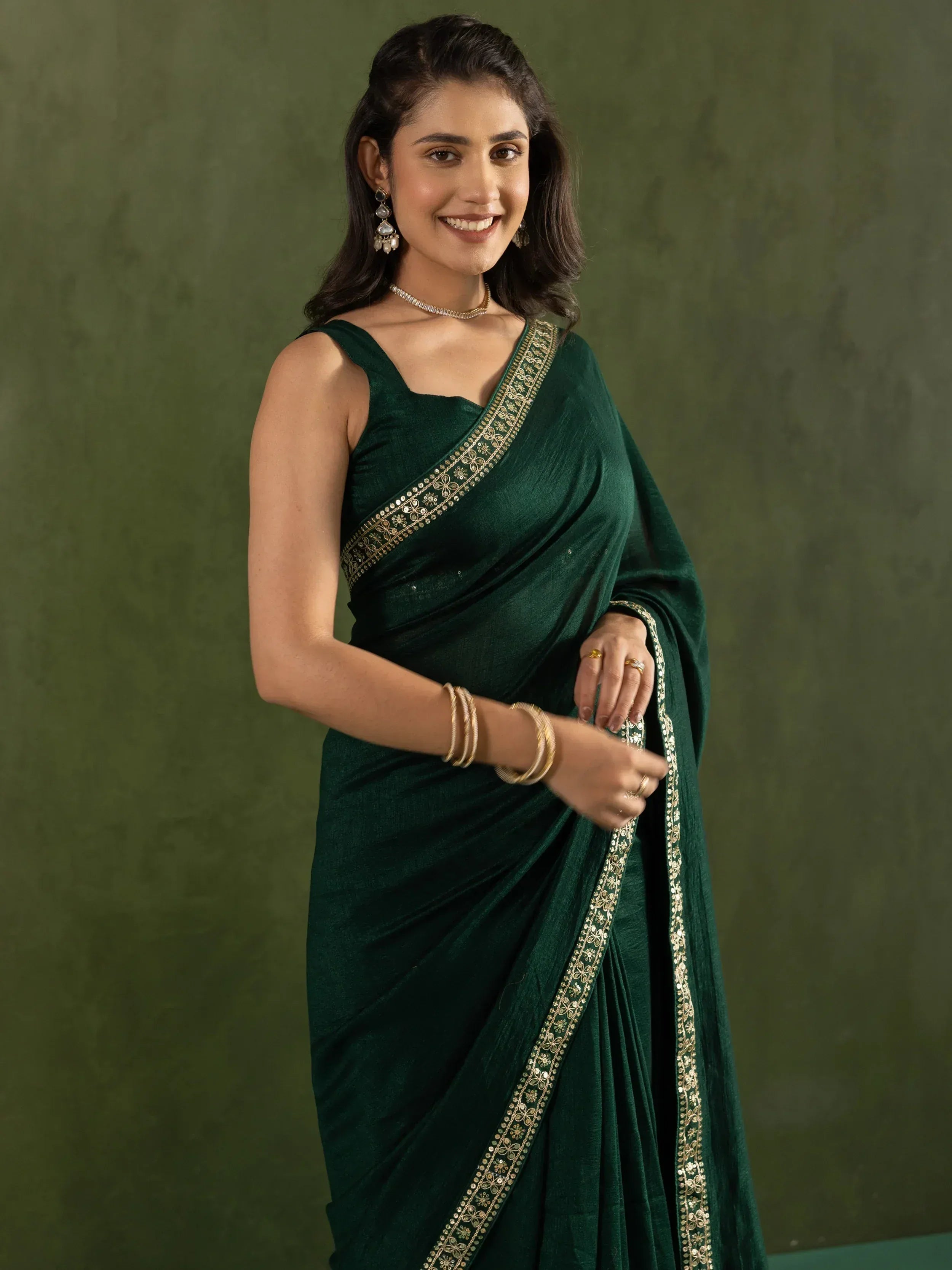 Woman in elegant green saree with gold embroidery, perfect for Indian ethnic wear occasions