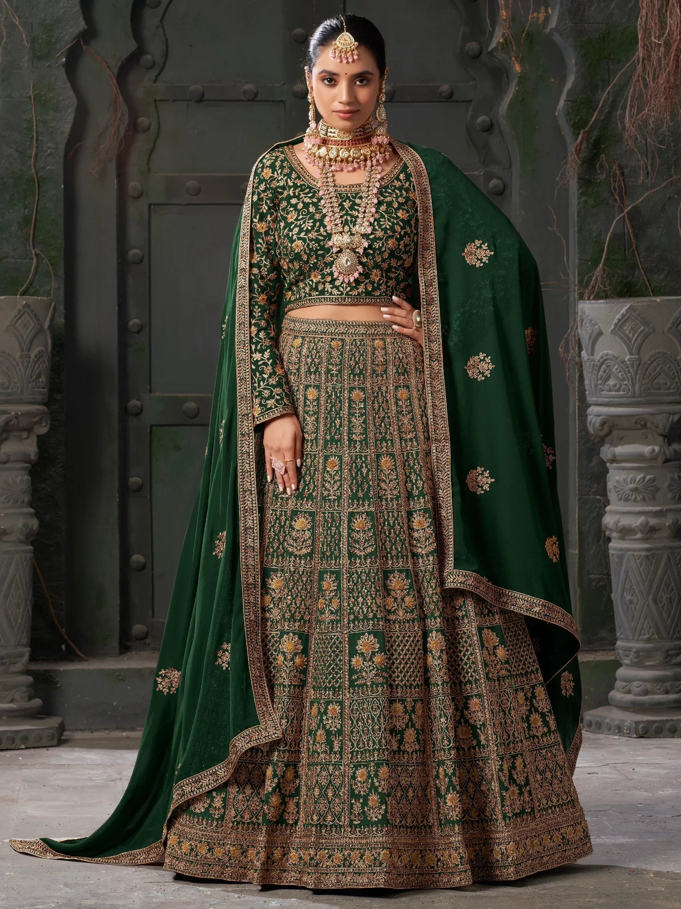 Emerald green designer lehenga choli with gold embroidery, perfect for Indian weddings and festive occasions.