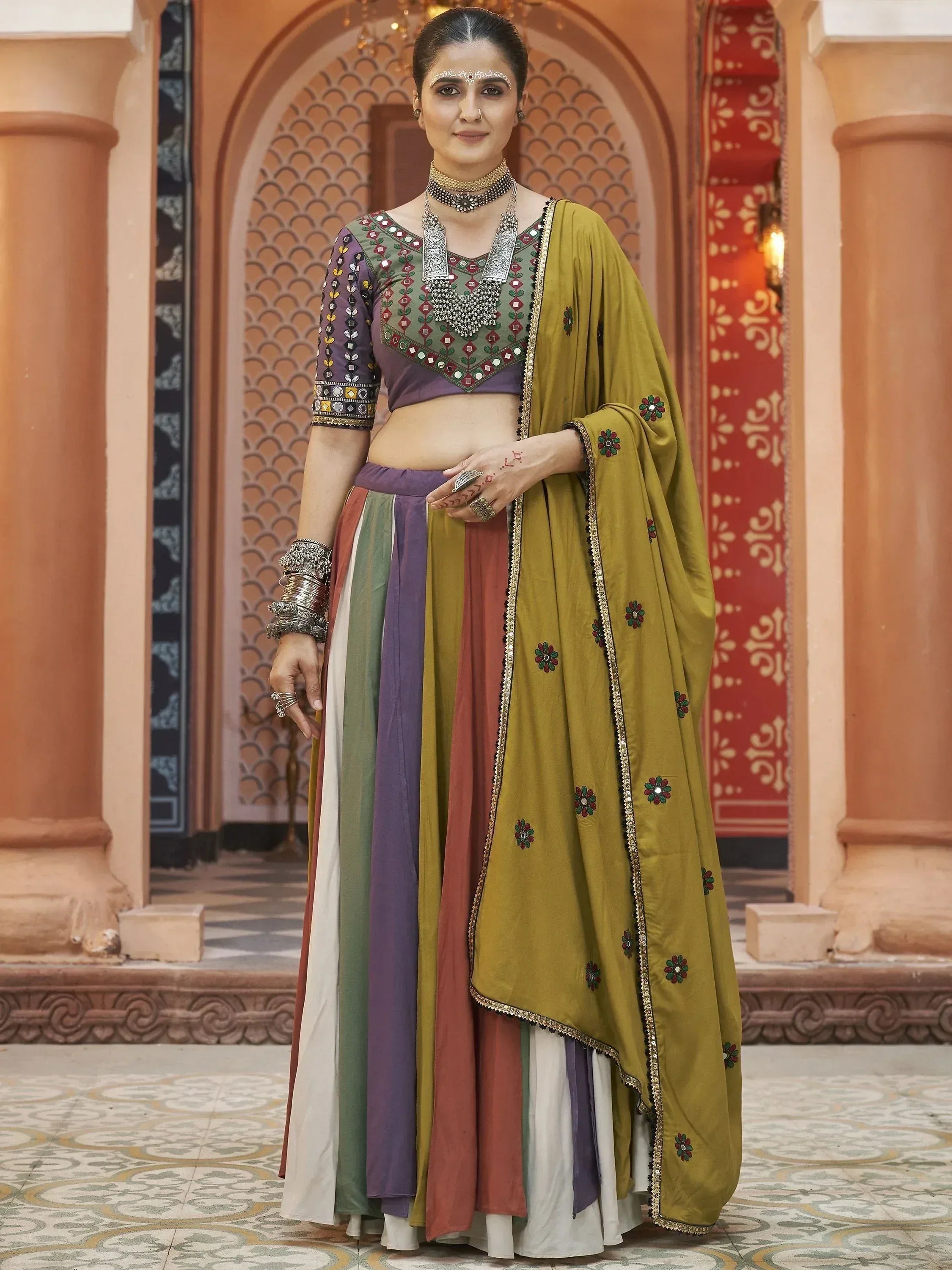 Woman in colorful Indian ethnic lehenga choli with mirror work and floral dupatta, traditional jewelry