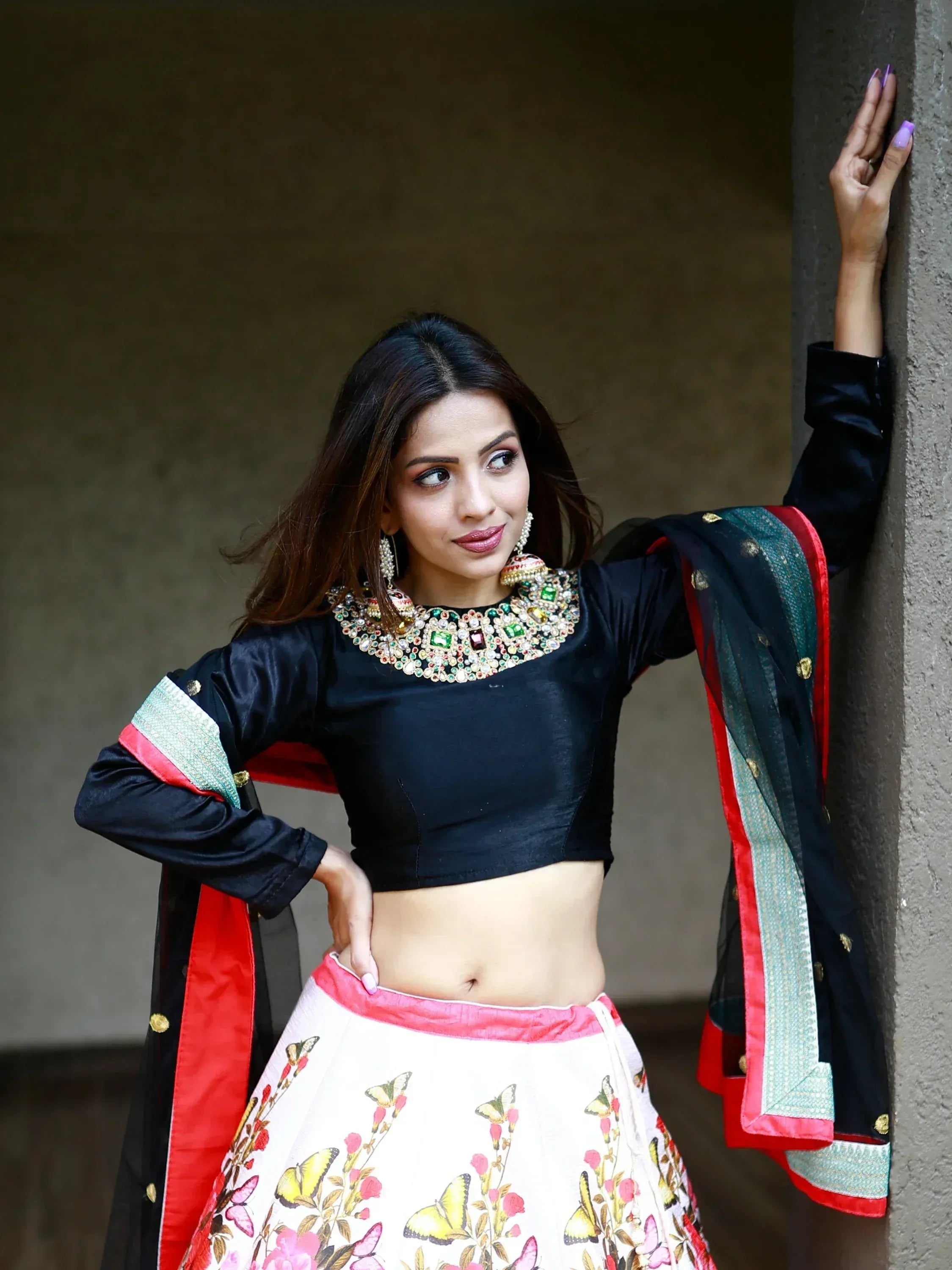 Woman in black embroidered crop top and floral lehenga skirt with dupatta, Indian ethnic wear