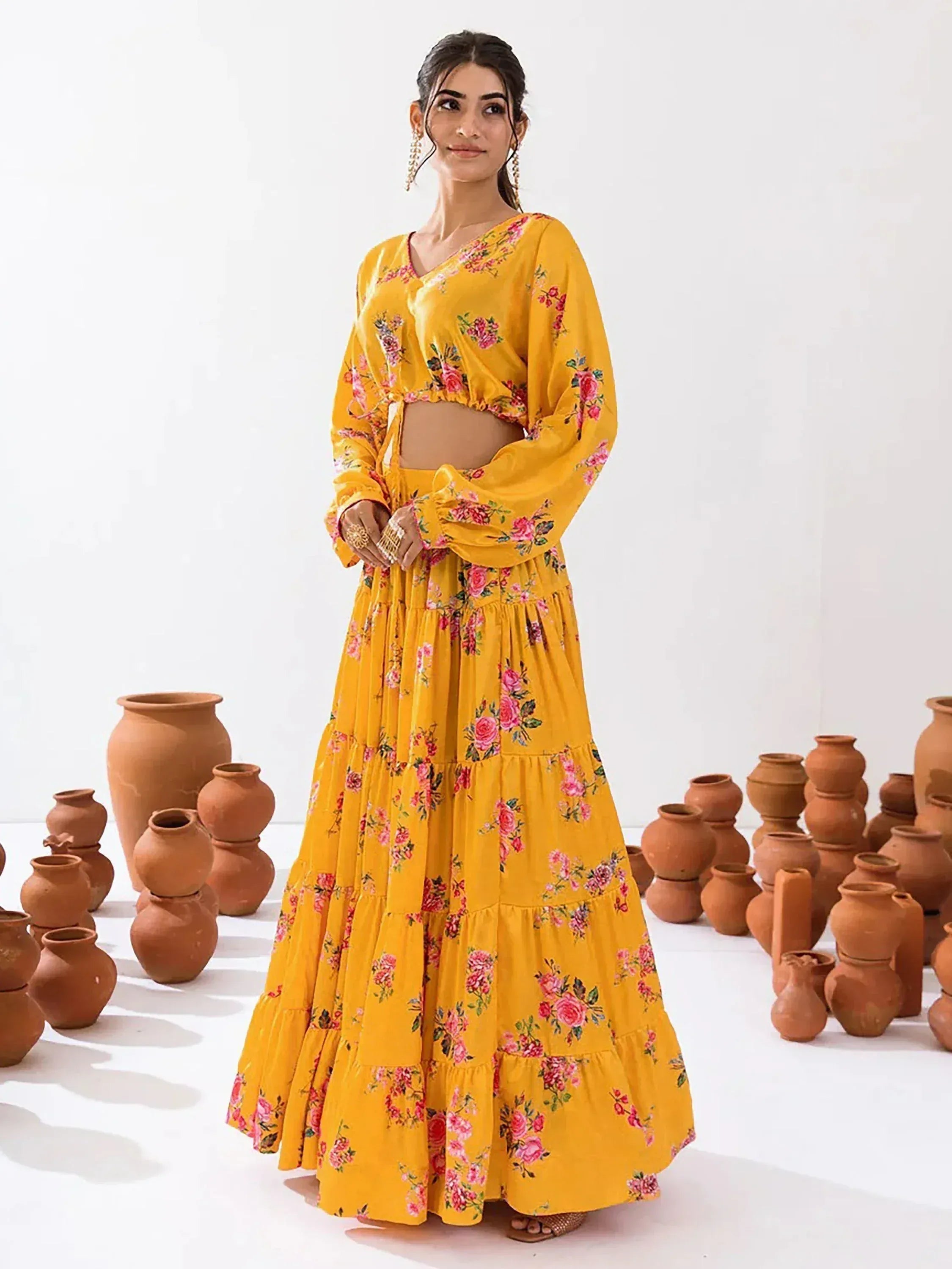 Yellow floral printed ethnic gown with tiered skirt and long sleeves, styled with clay pots