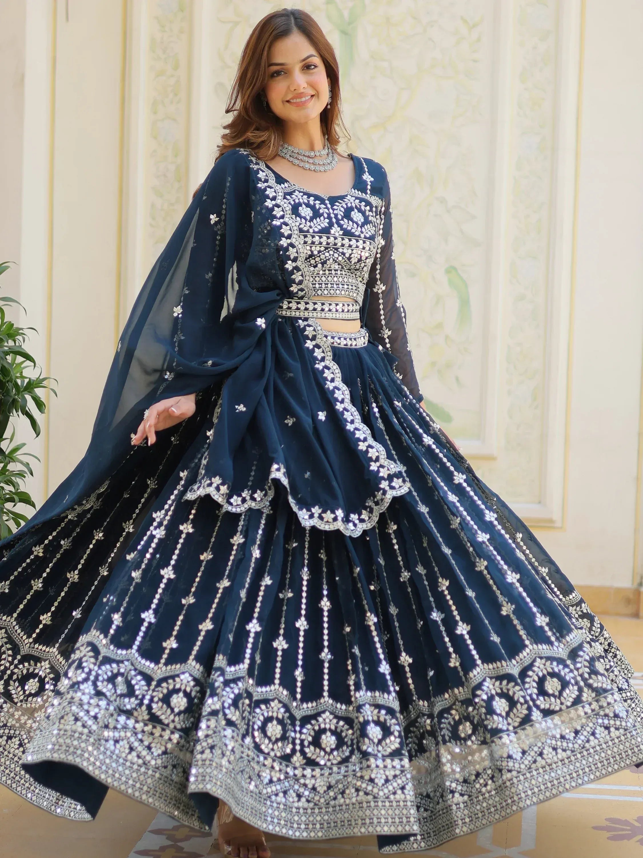 Navy blue designer lehenga choli with heavy silver embroidery and sheer dupatta, perfect for weddings and parties.