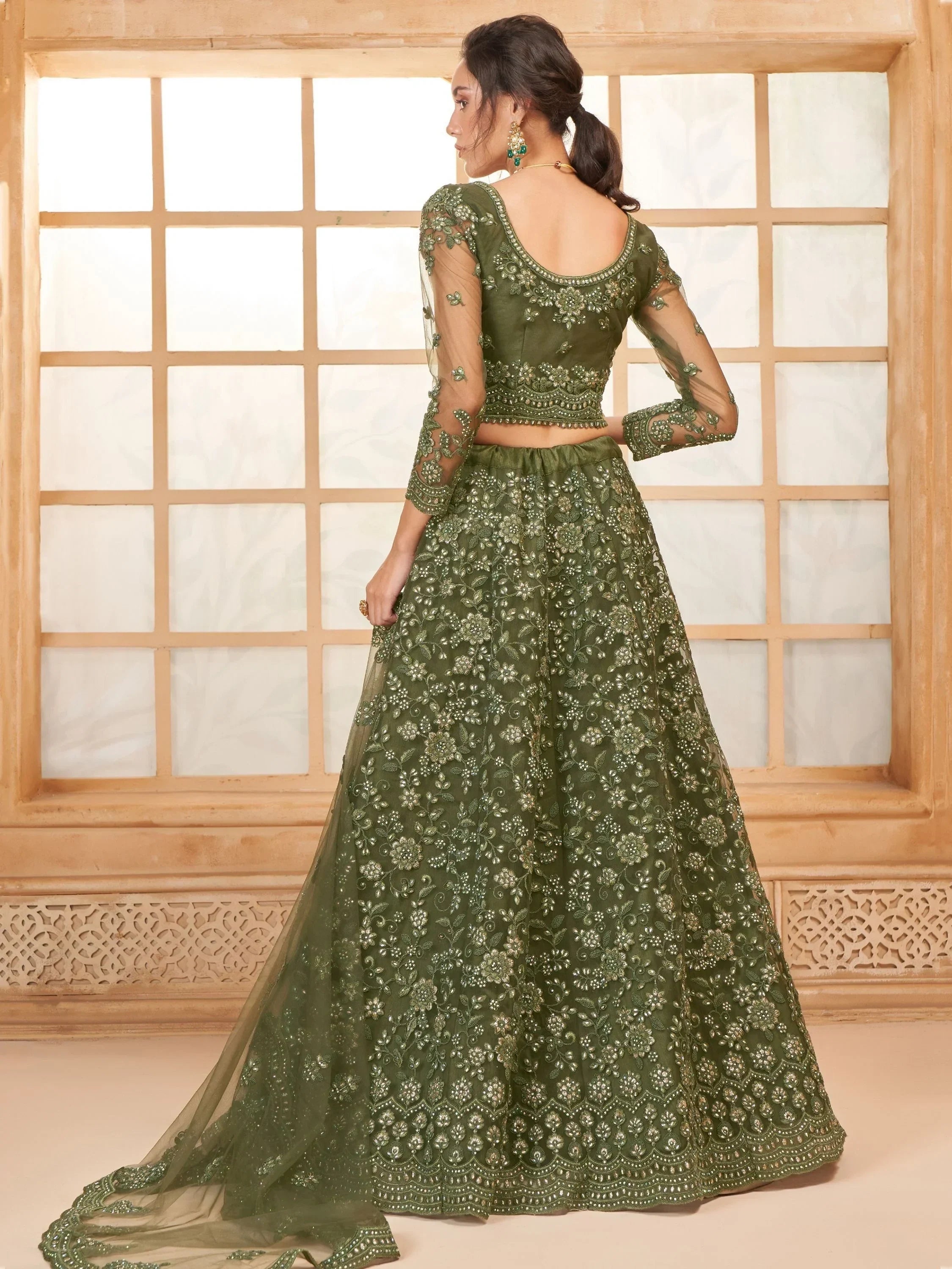 Olive green embroidered lehenga choli with sheer sleeves and floral detailing, perfect for Indian ethnic occasions.