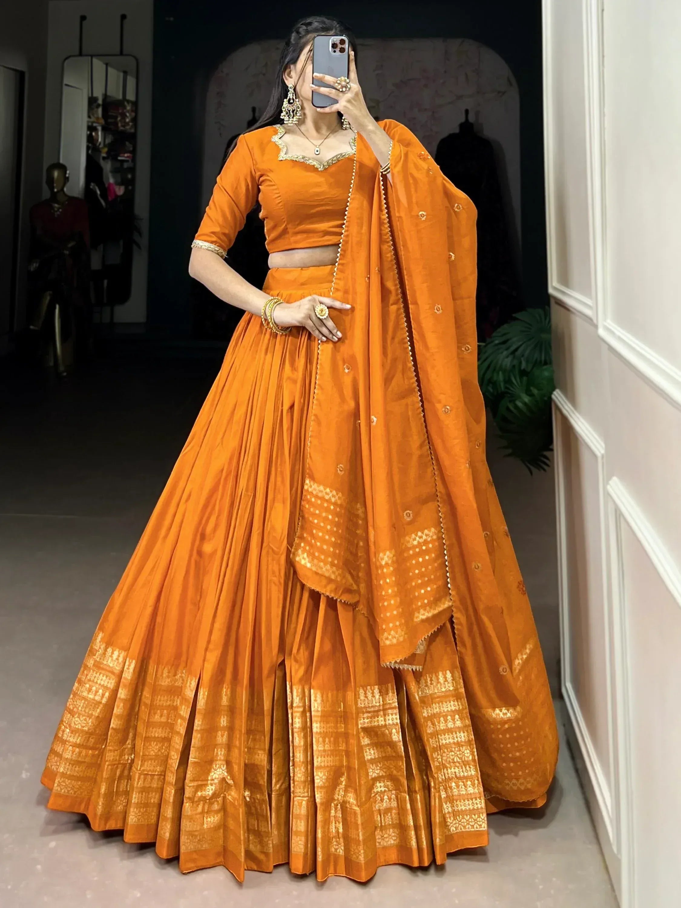 Orange designer lehenga choli with gold embroidery, perfect for Indian ethnic wear and festive occasions.
