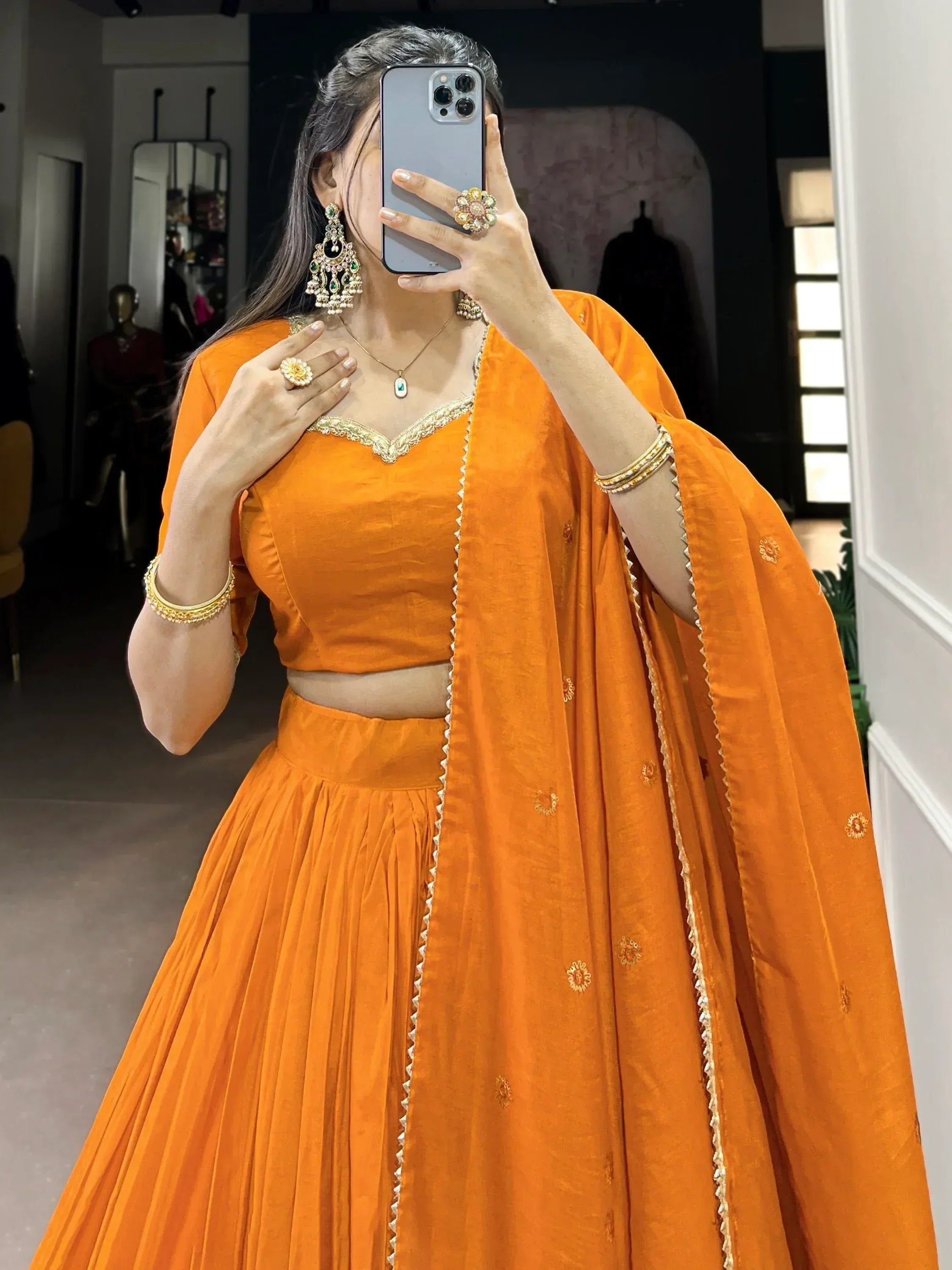 Vibrant orange lehenga choli with gold embroidery, perfect for Indian ethnic wear and festive occasions.