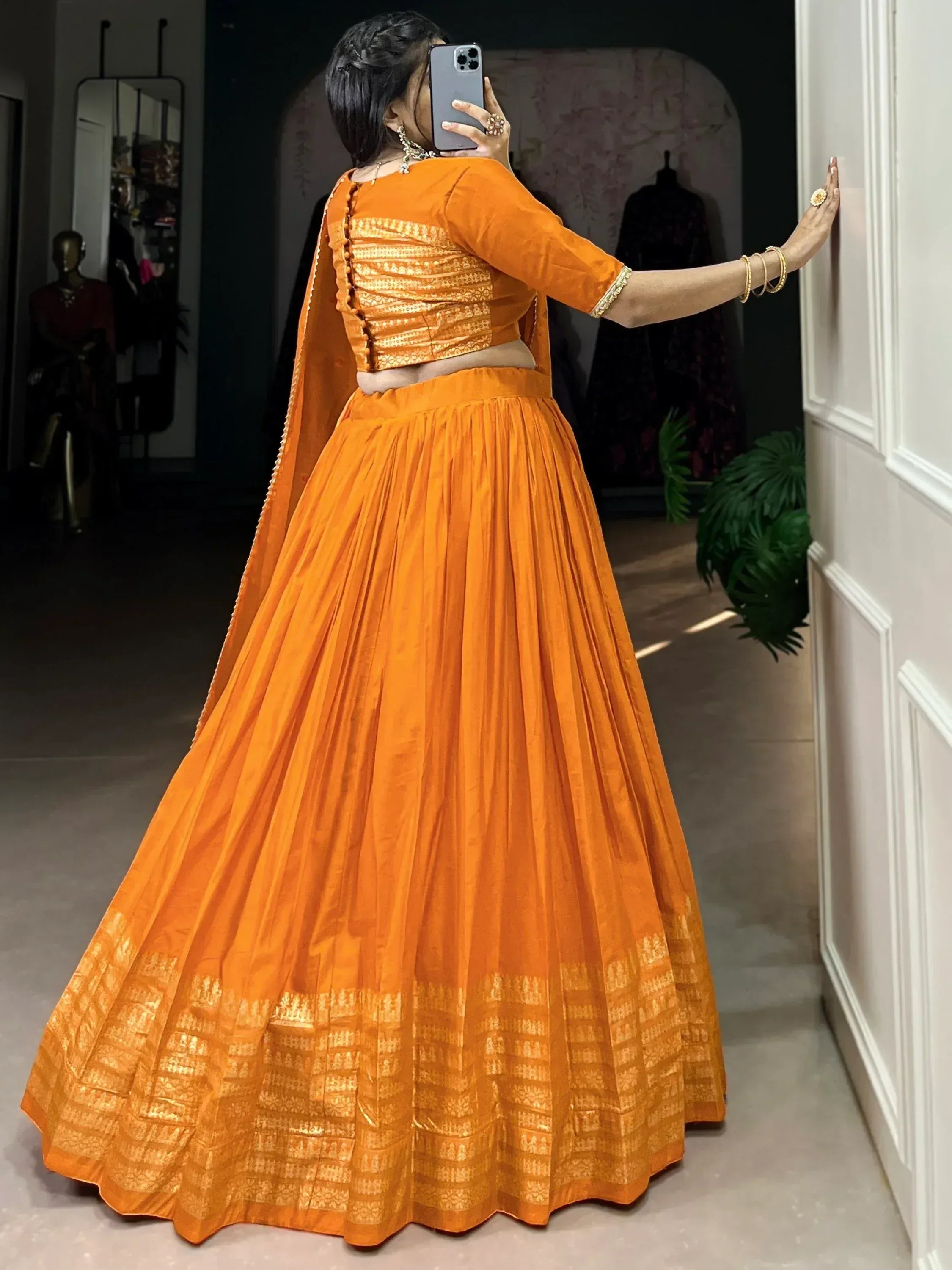Vibrant orange lehenga choli with gold embroidery, perfect for Indian ethnic wear and festive occasions.