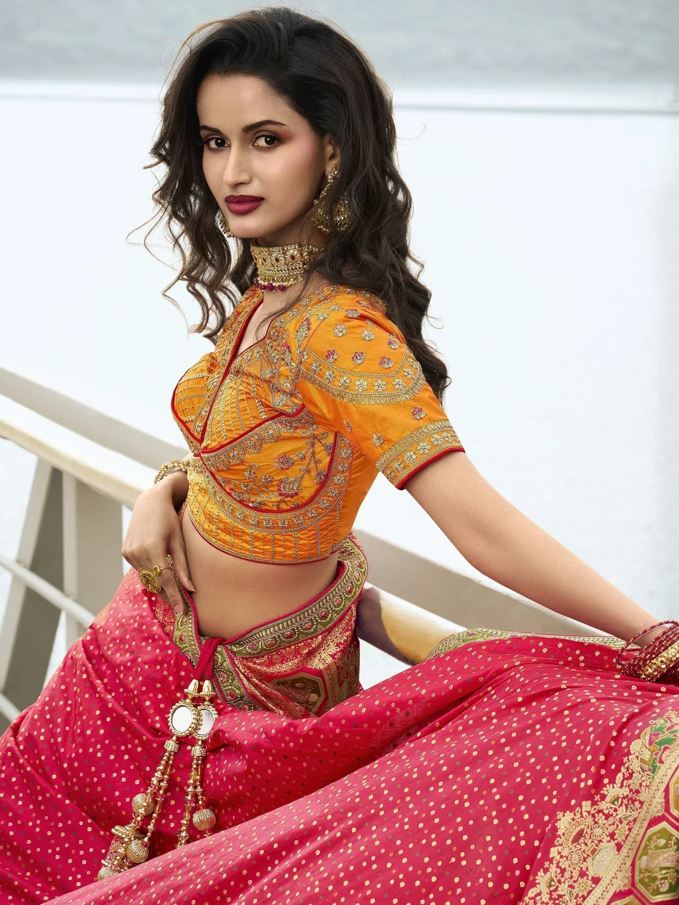 Woman in vibrant red and gold ethnic saree with embroidered blouse, perfect for Indian celebrations