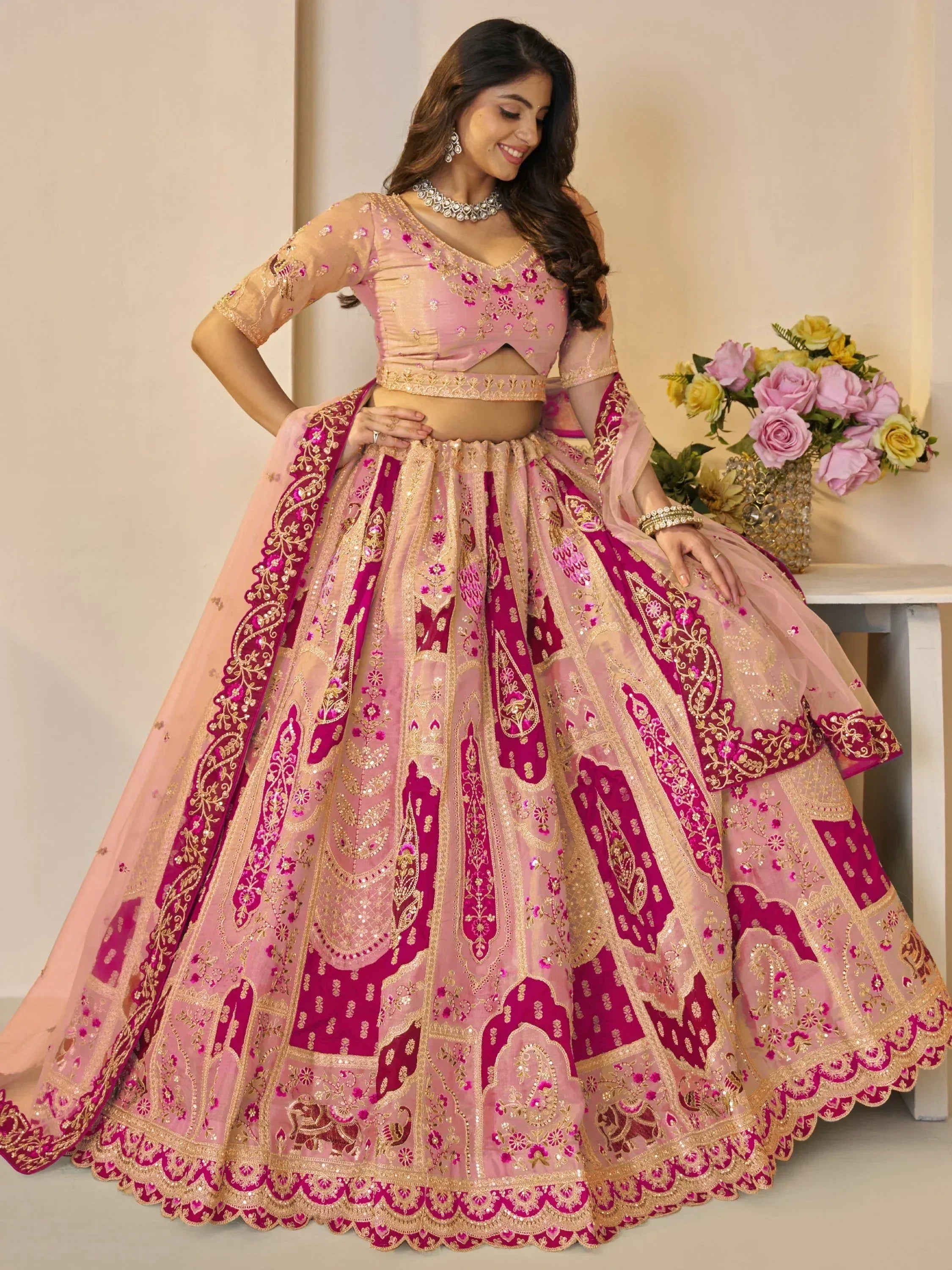 Pink and magenta embroidered lehenga choli with gold detailing, perfect for Indian weddings and festive occasions.