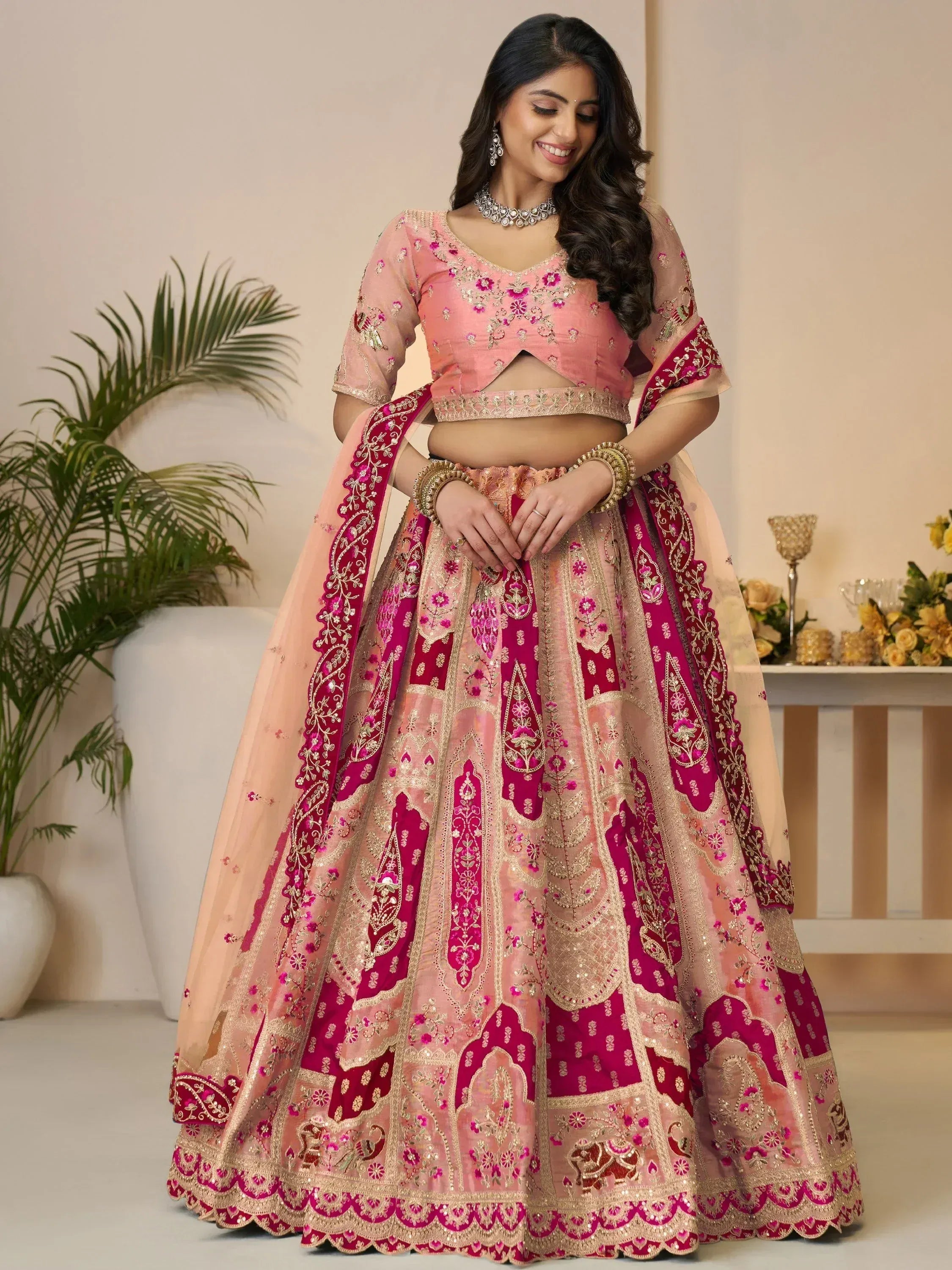 Pink and magenta embroidered lehenga choli with gold detailing, perfect for Indian weddings and festive occasions.