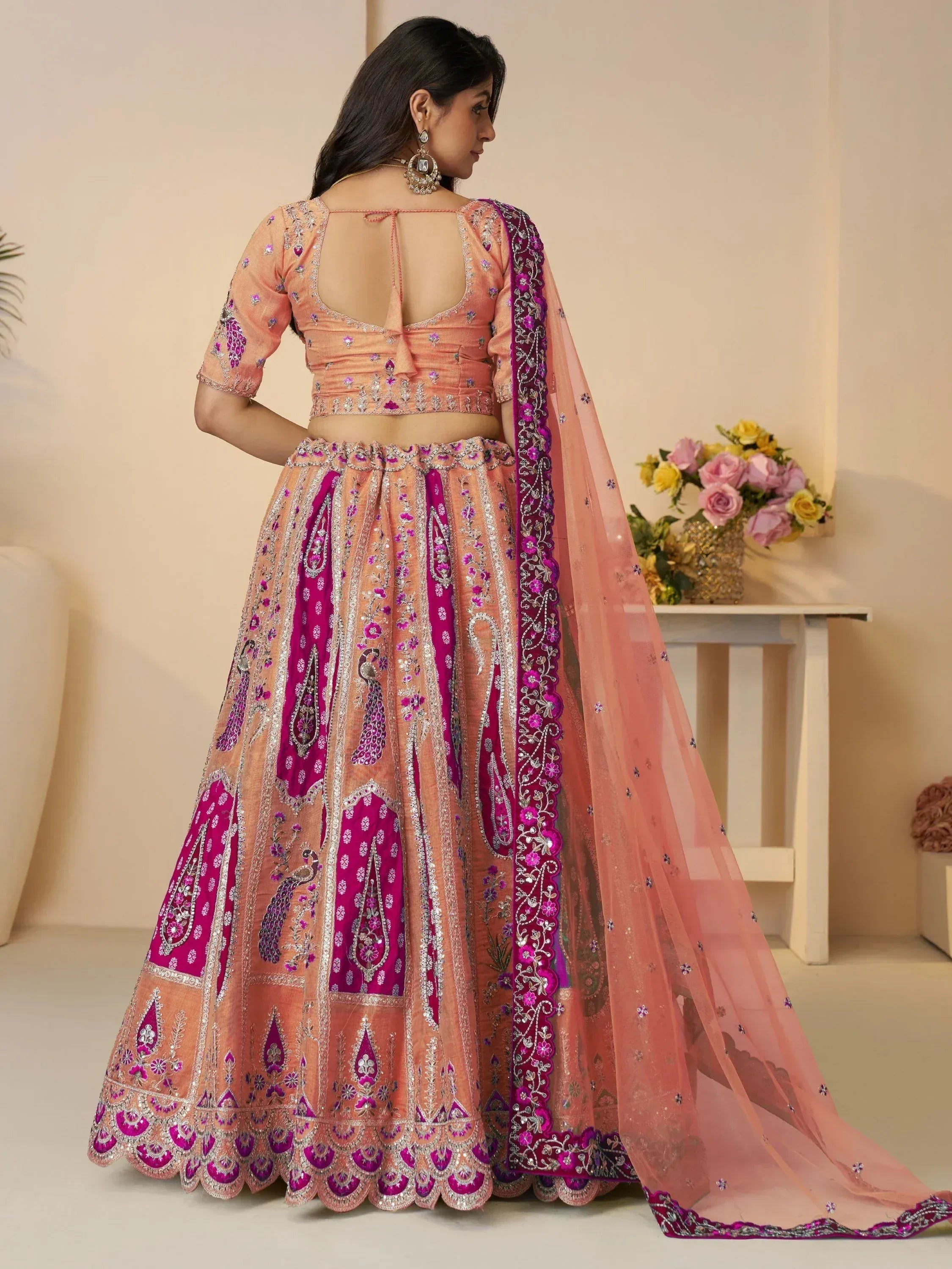 Peach and magenta embroidered lehenga choli with peacock motifs and sheer dupatta, ideal for Indian ethnic occasions