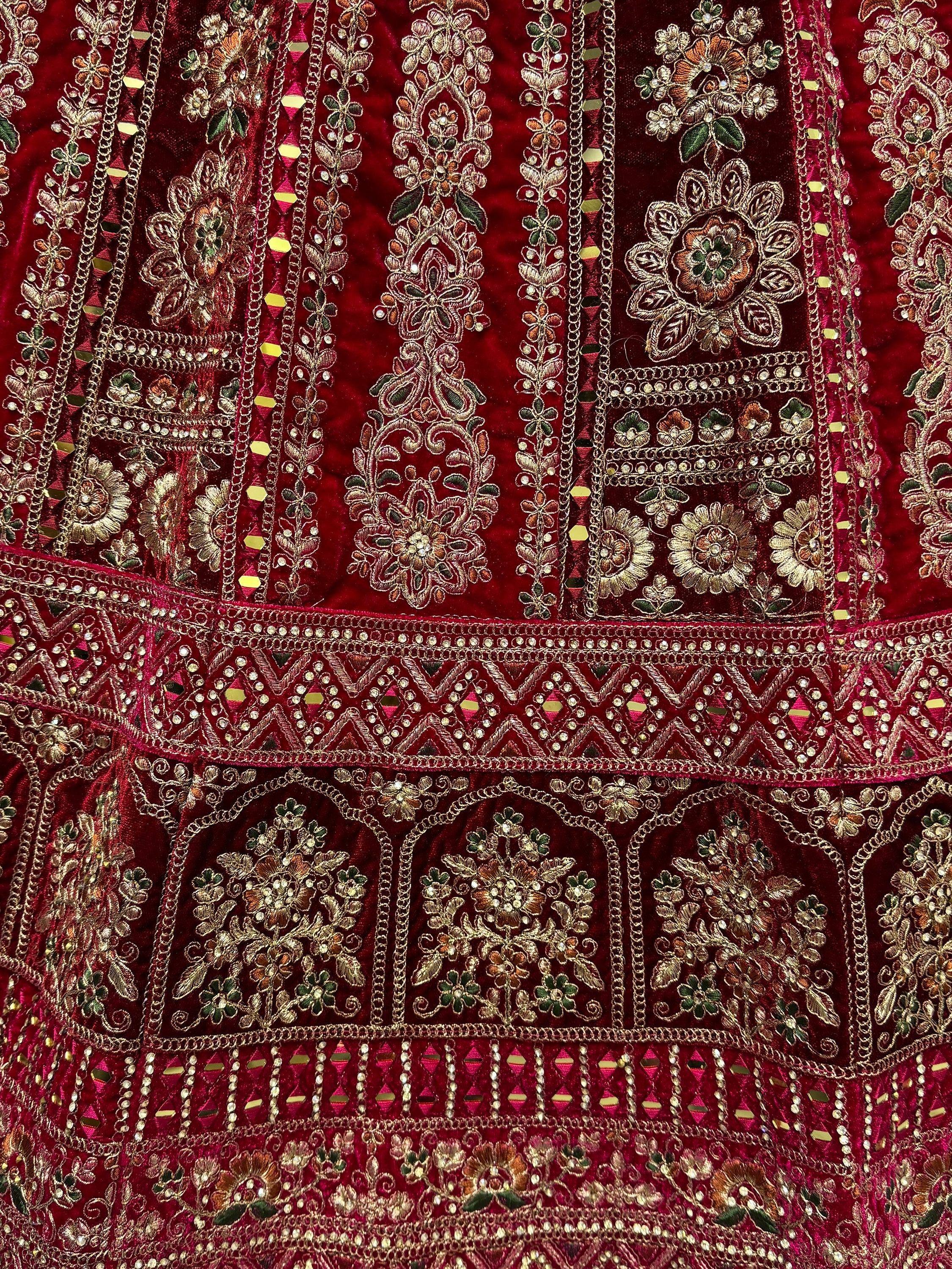 Richly embroidered maroon velvet ethnic gown with gold floral motifs and mirror work detailing