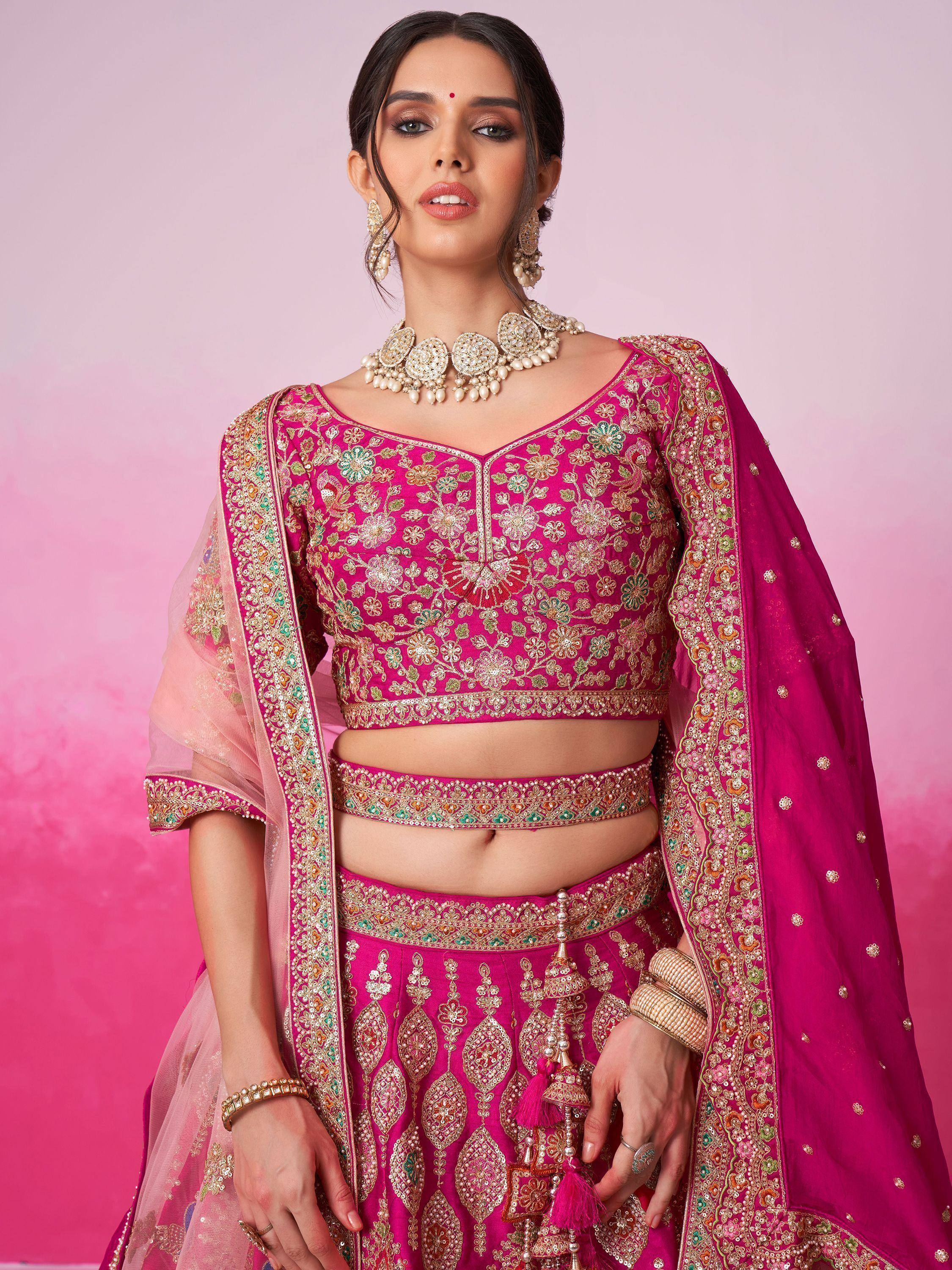 Fuchsia embroidered lehenga choli with floral motifs, dupatta, and traditional jewelry for Indian ethnic wear