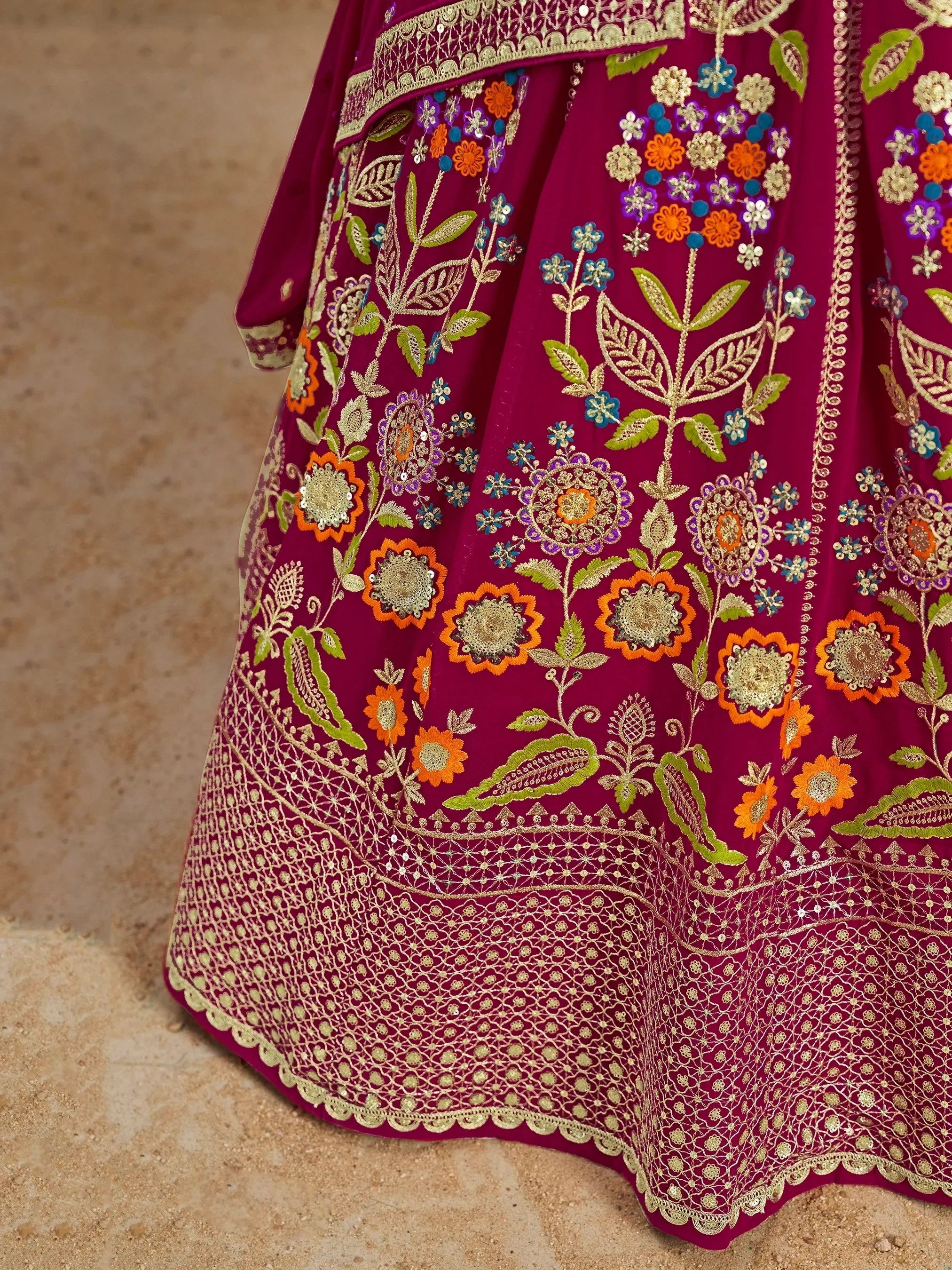 Richly embroidered maroon lehenga with floral motifs, gold threadwork, and colorful sequins for Indian ethnic wear.