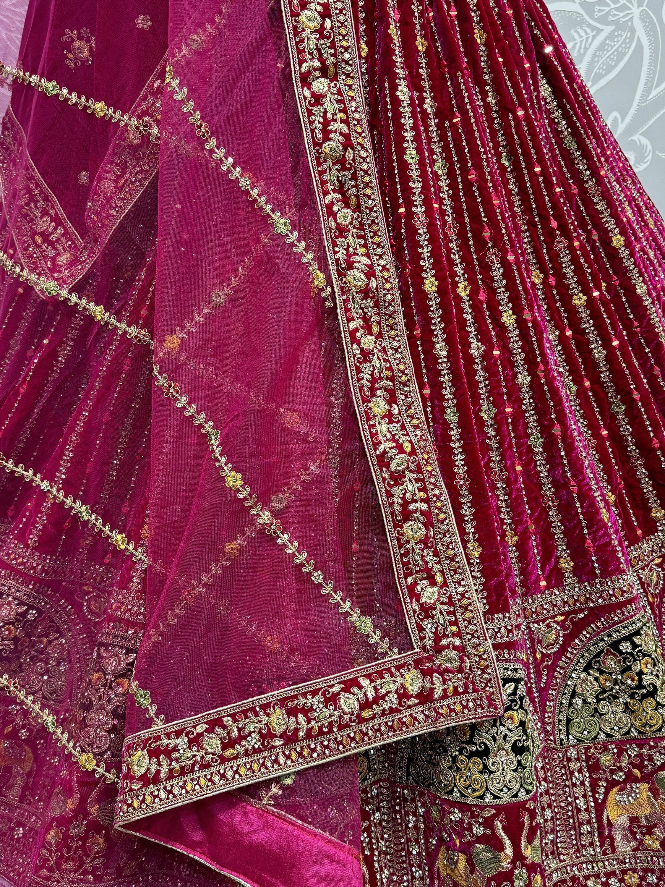 Luxury maroon velvet lehenga choli with gold embroidery and sheer dupatta, perfect for Indian weddings and festive occasions.