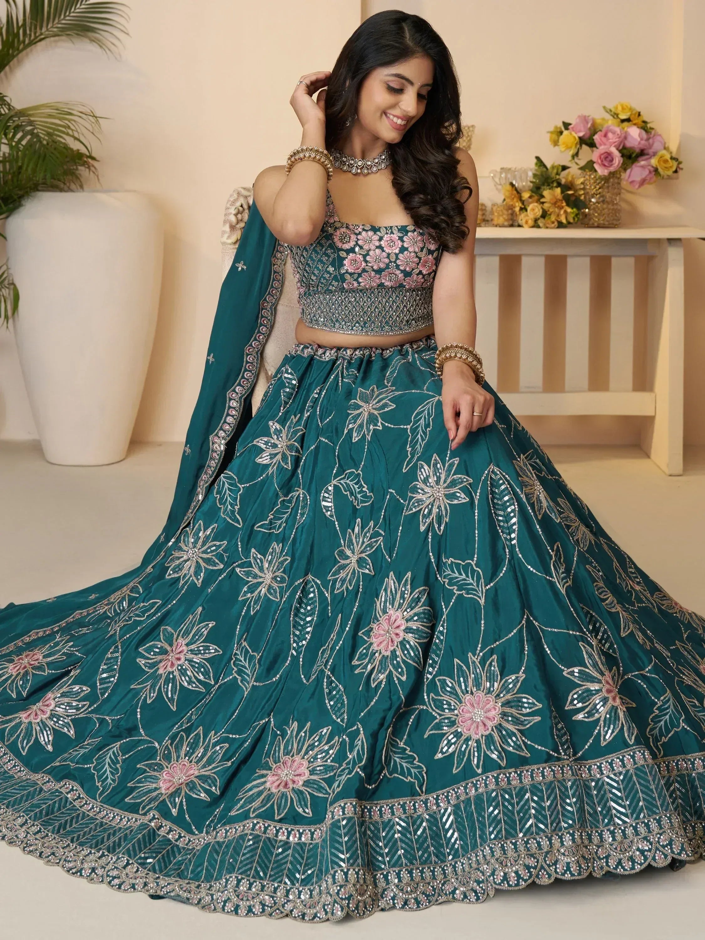 Teal floral embroidered lehenga choli with pink accents, perfect for Indian weddings and festive occasions