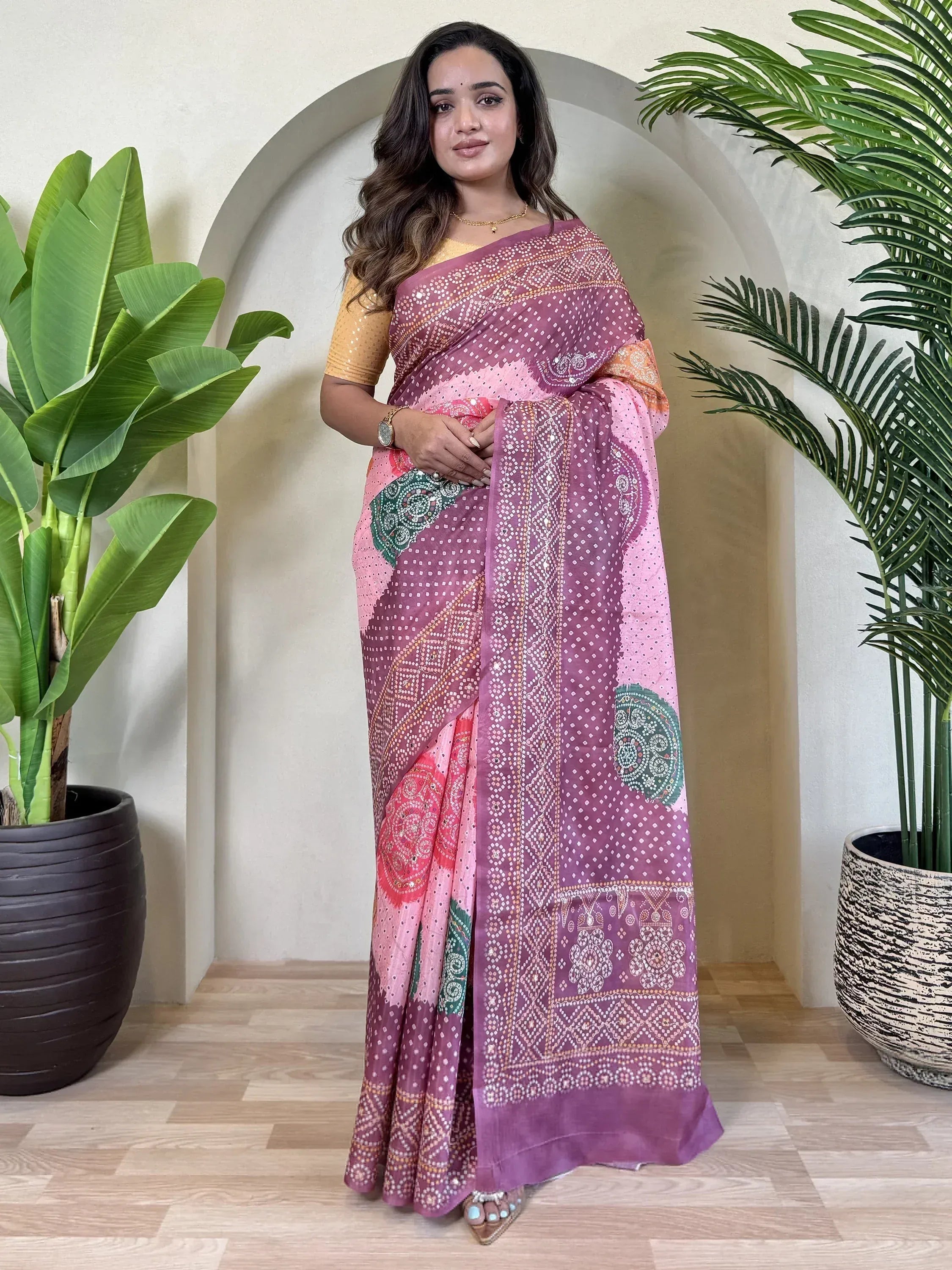 Woman in purple and pink printed saree with gold blouse, ethnic Indian wear for festive occasions
