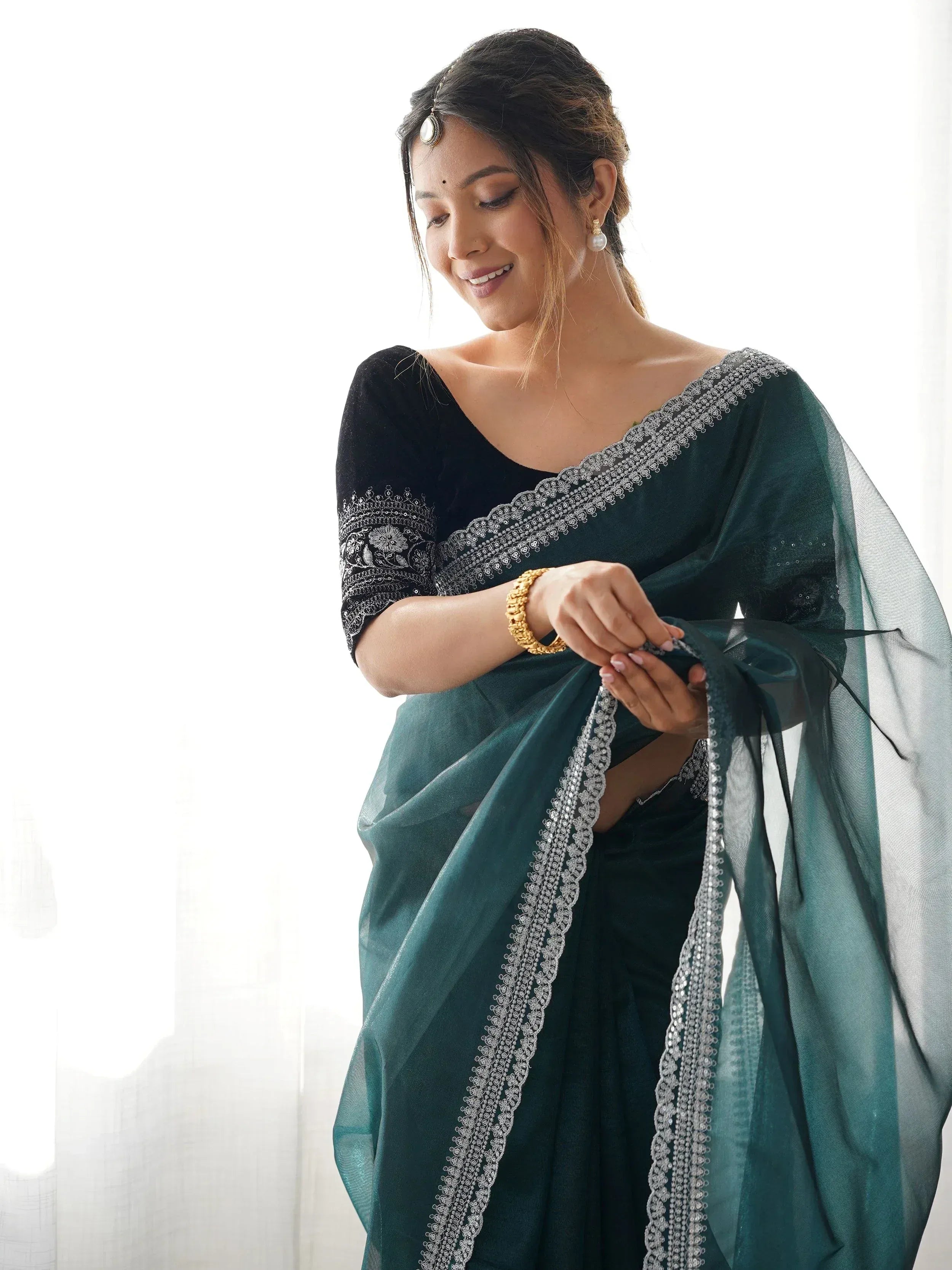 Elegant woman in dark green saree with silver embroidery and black velvet blouse, traditional Indian ethnic wear