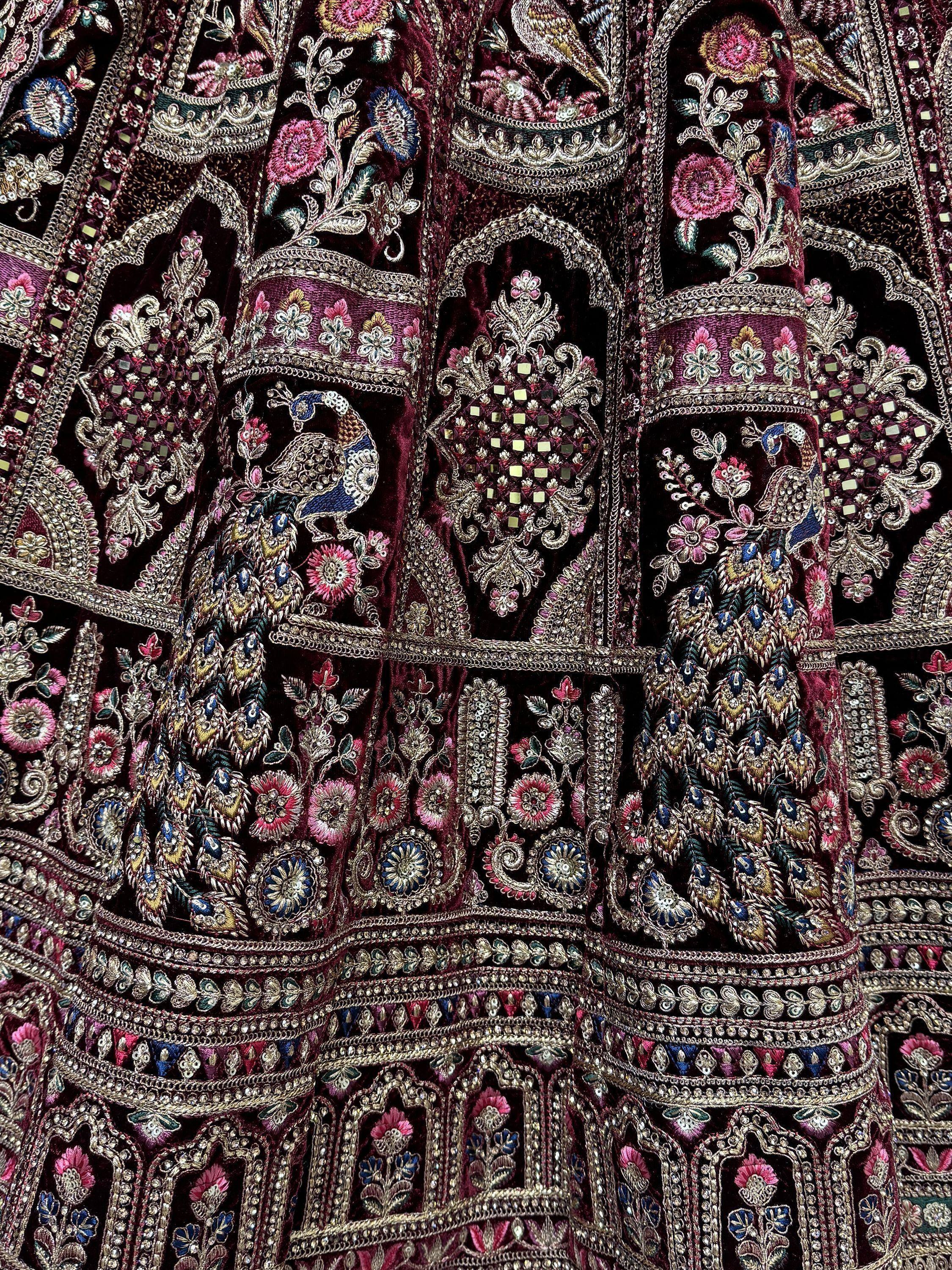 Richly embroidered maroon velvet lehenga with peacock and floral motifs, perfect for Indian ethnic wear.