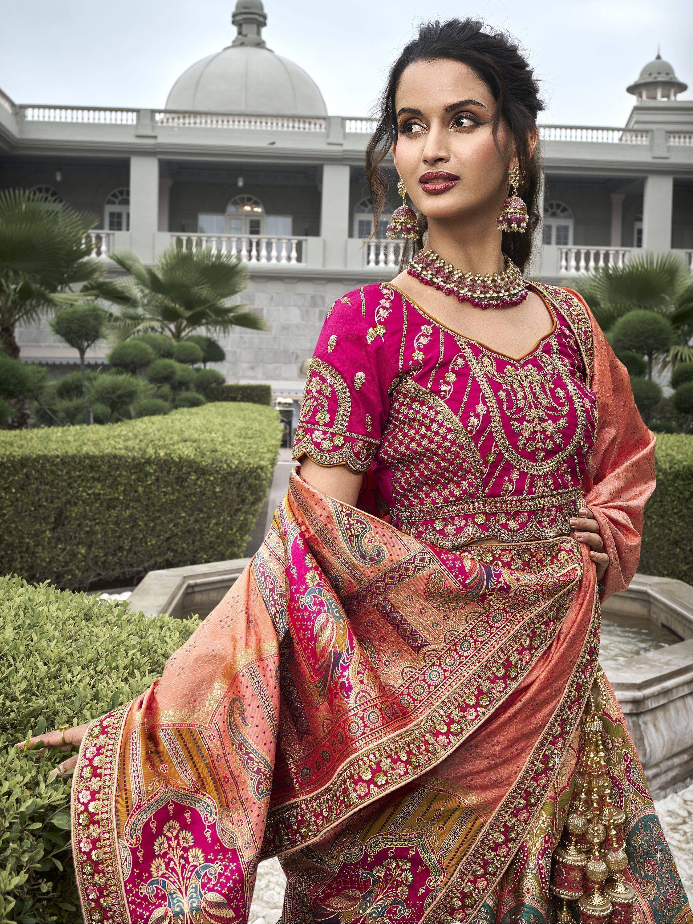 Elegant Indian woman in pink and gold embroidered lehenga choli with paisley dupatta, traditional jewelry, palace garden backdrop