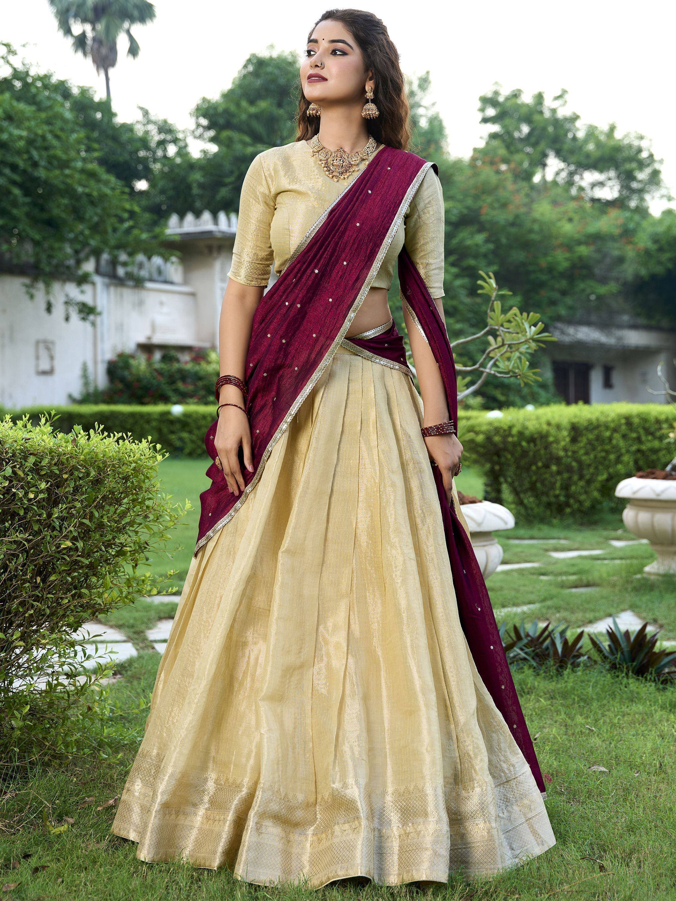 Woman in golden lehenga choli with maroon dupatta, ethnic Indian wear for weddings and festivals