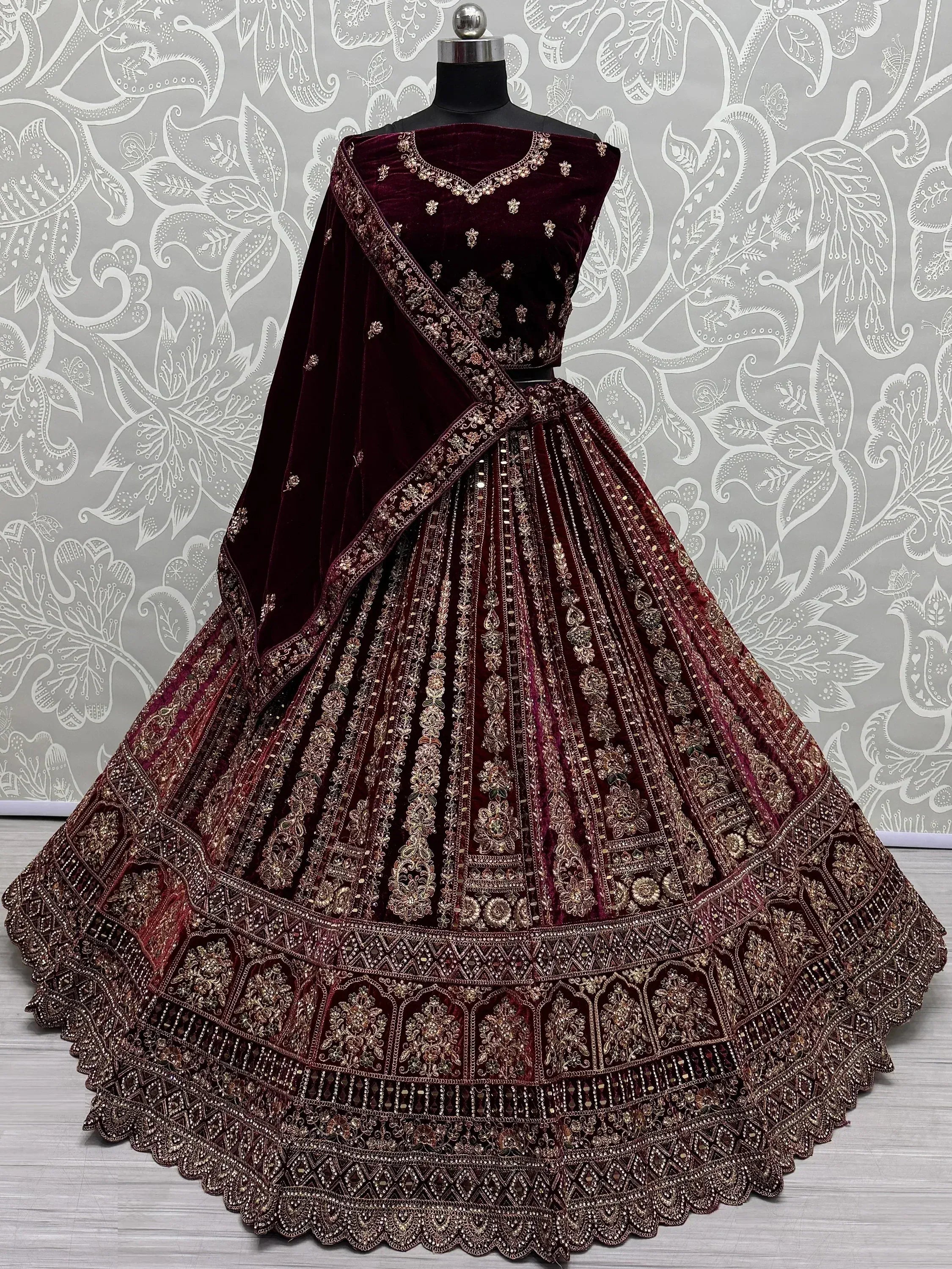 Burgundy velvet lehenga choli with gold embroidery, perfect for Indian weddings and festive occasions.