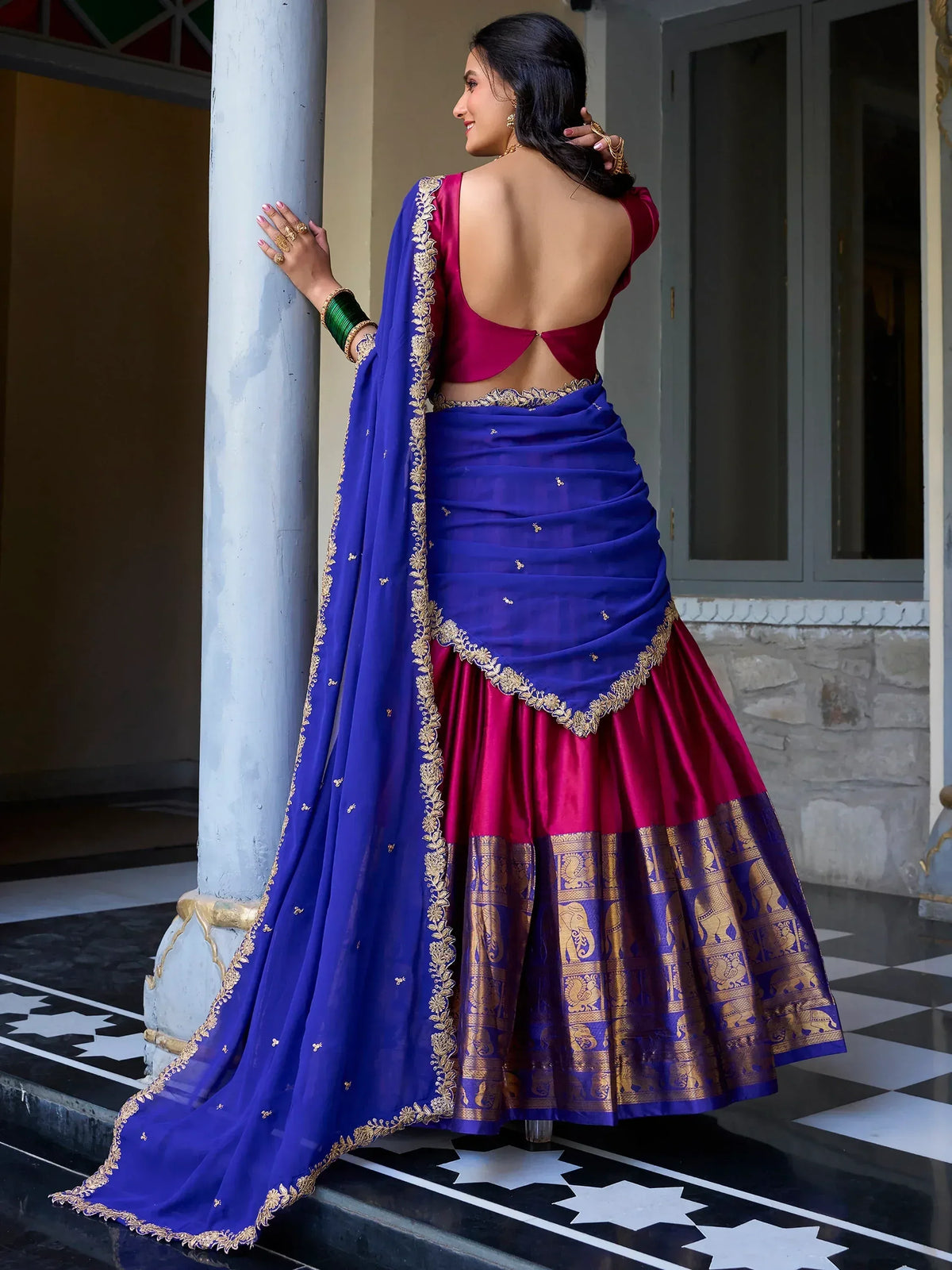 Royal blue and magenta lehenga choli with gold embroidery, backless blouse, and elephant motif border for Indian ethnic wear
