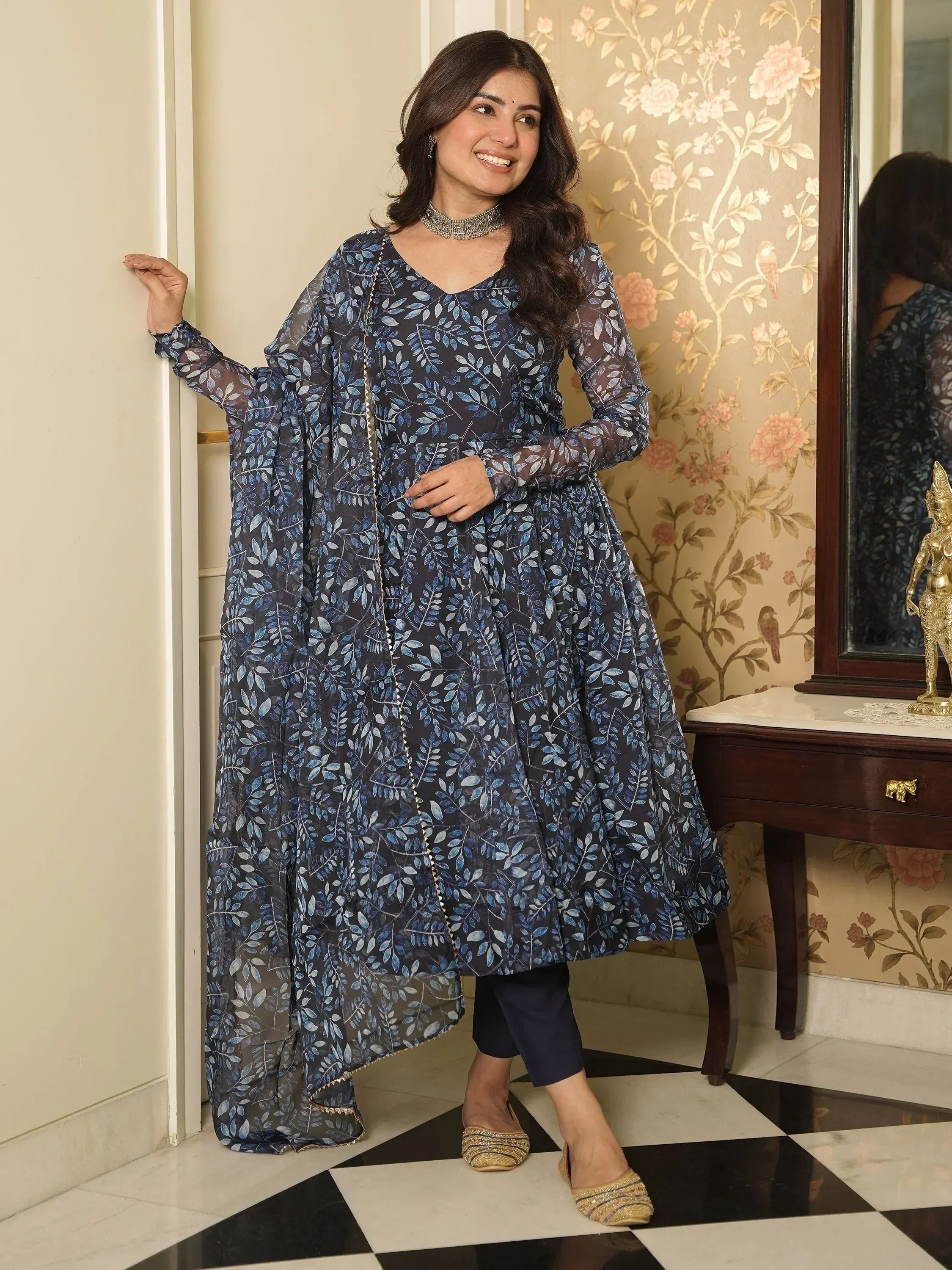 Woman in navy blue leaf-print anarkali with sheer cape, styled for ethnic occasions