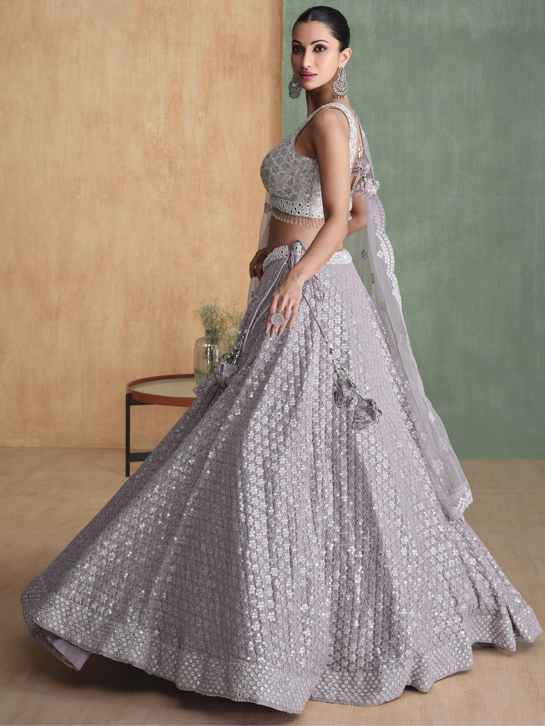 Elegant lavender lehenga choli with intricate silver embroidery and sequins, perfect for Indian weddings and festive occasions.