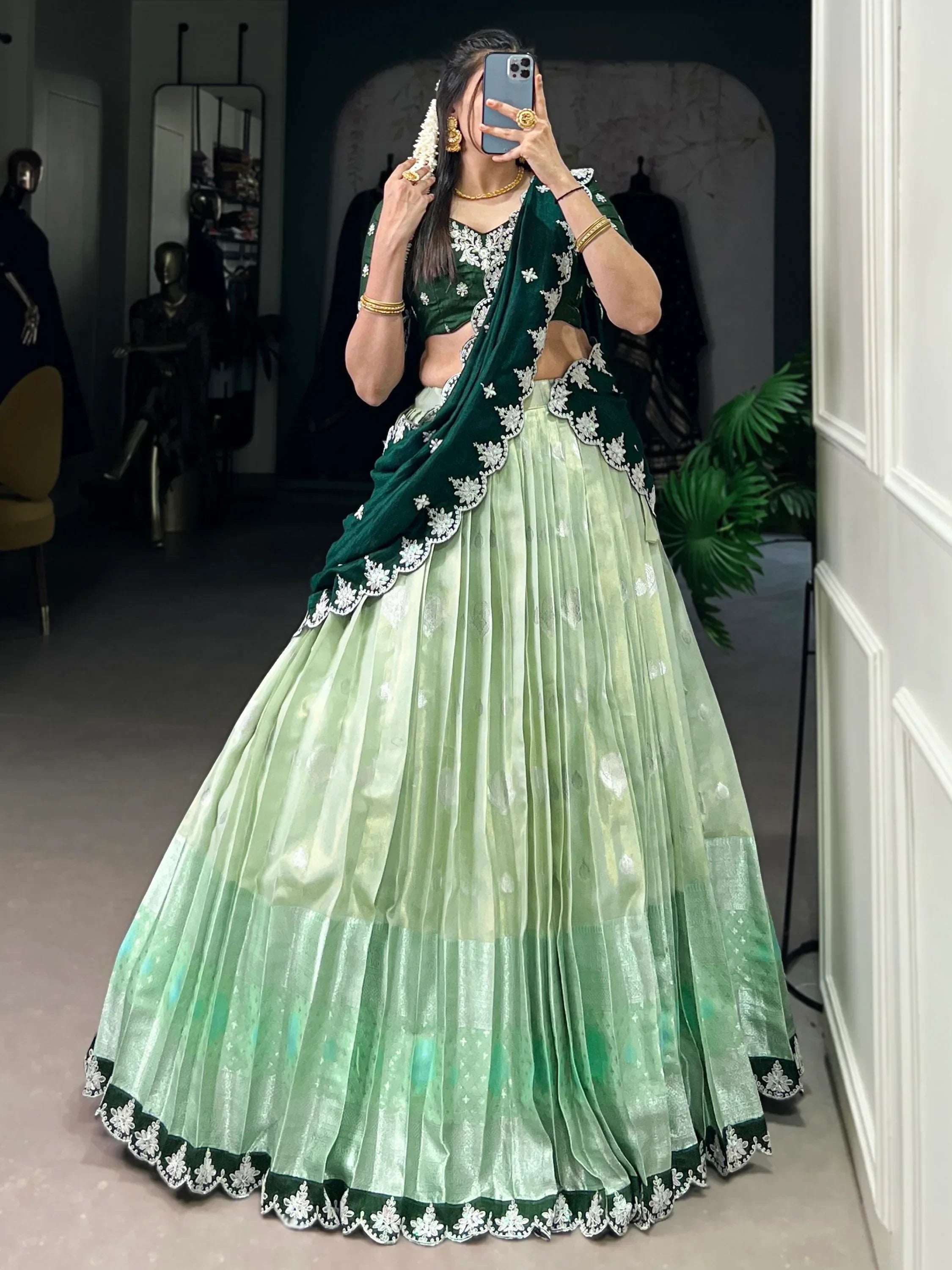 Green velvet lehenga choli with white embroidery, perfect for Indian weddings and festive occasions.