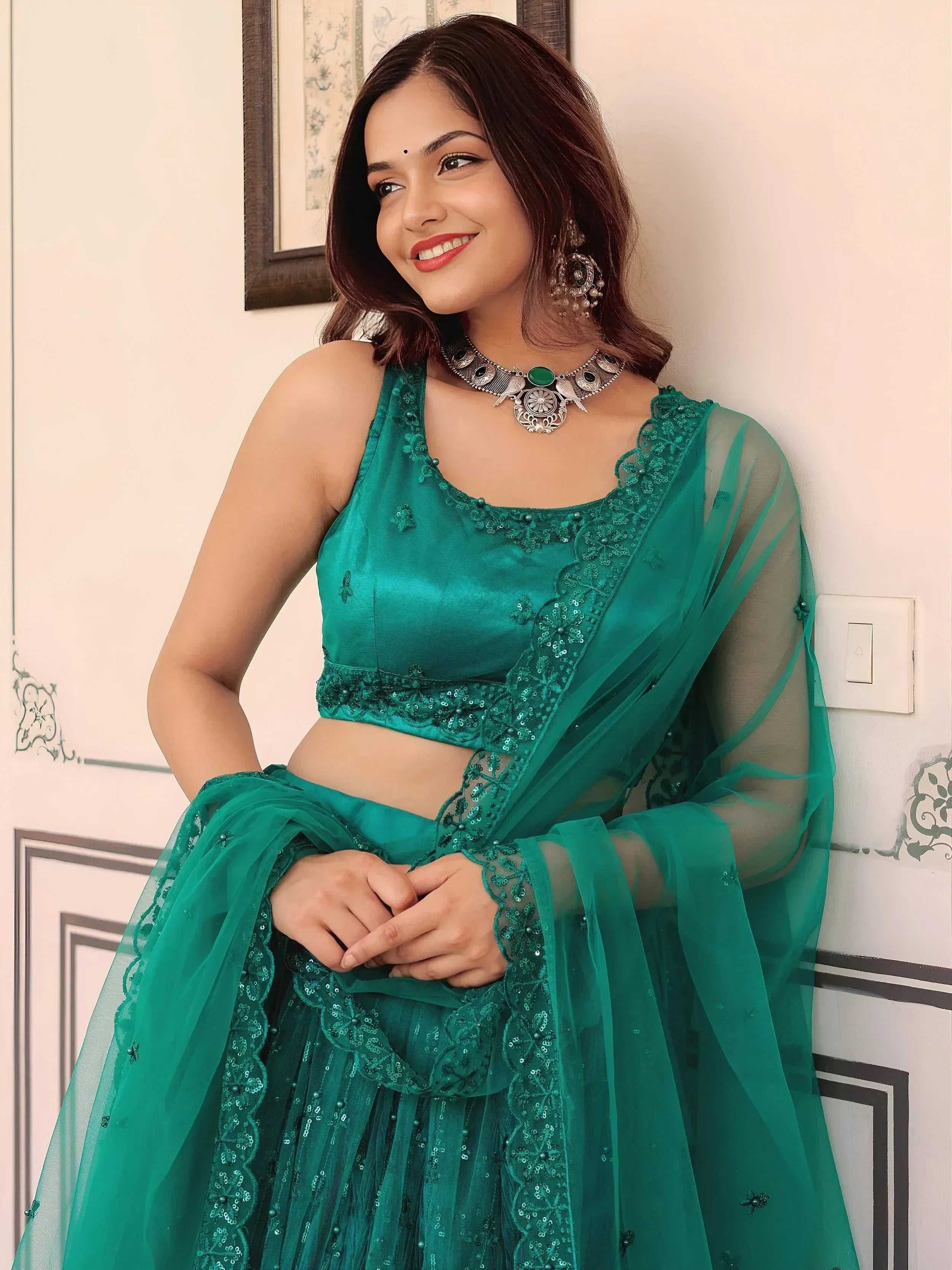 Emerald green embroidered lehenga choli with sheer dupatta, perfect for Indian ethnic wear occasions.