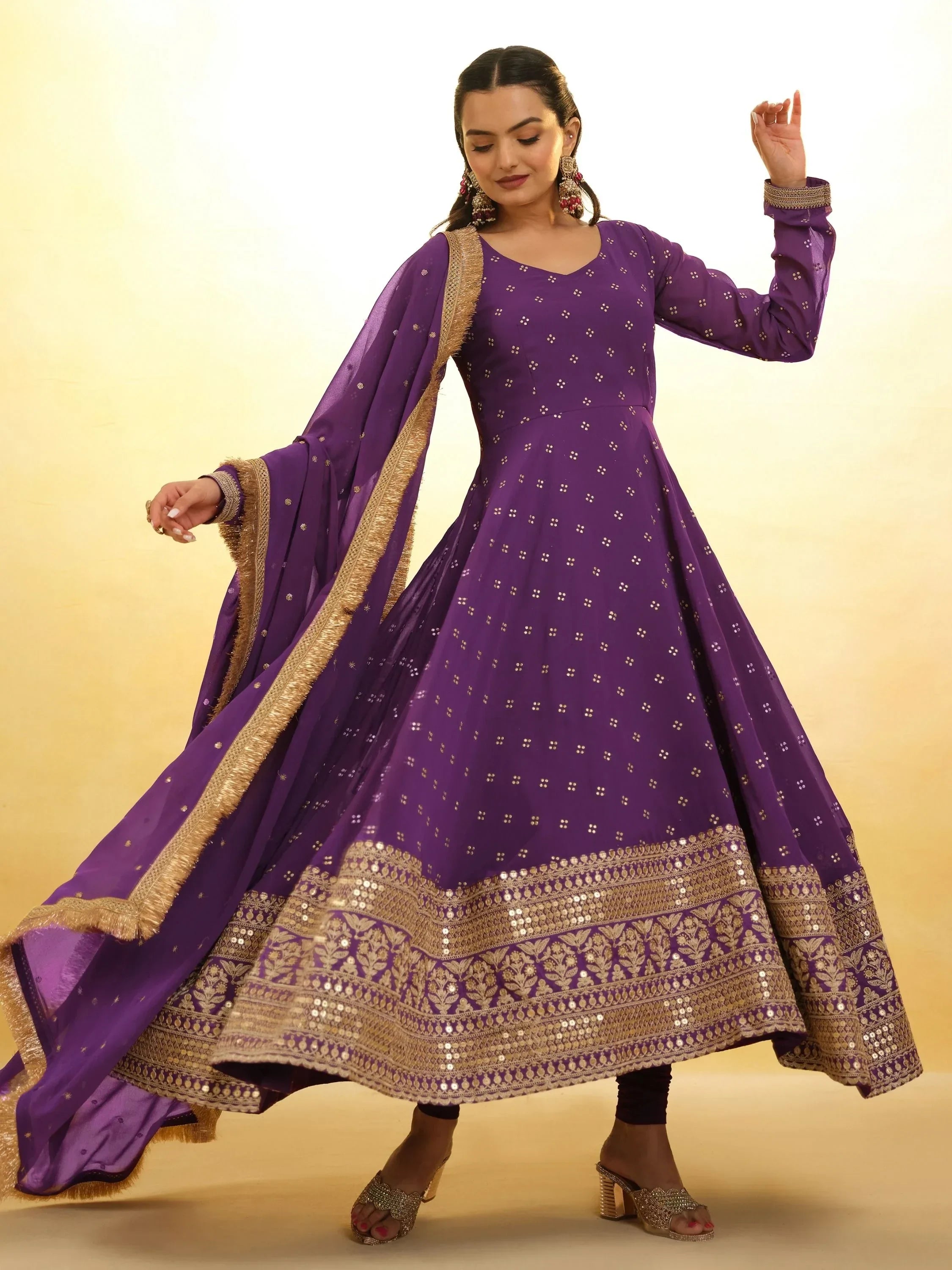 Woman wearing purple Anarkali suit with gold embroidery and matching dupatta, traditional Indian ethnic wear