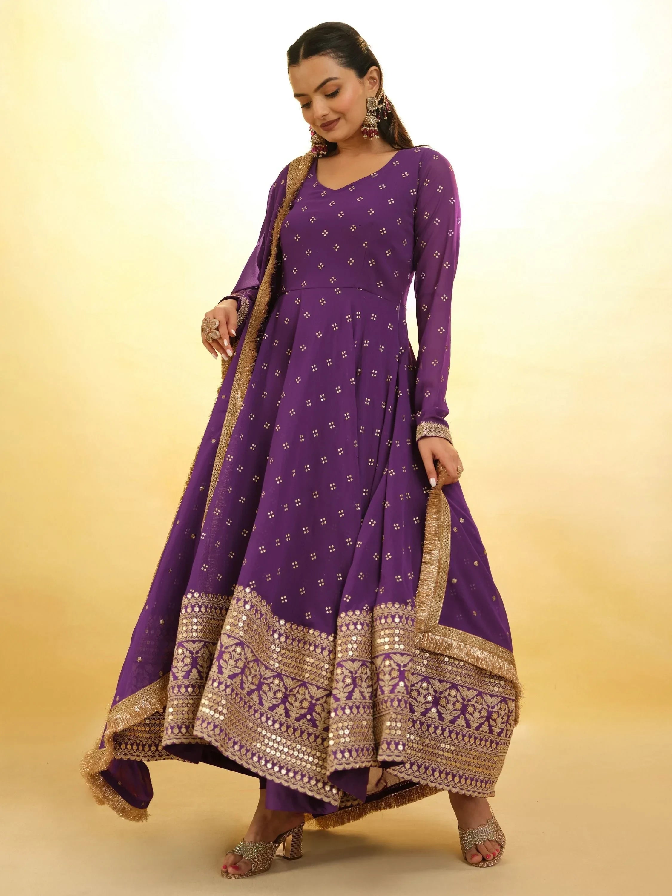 Woman wearing purple ethnic Anarkali suit with gold embroidery and dupatta