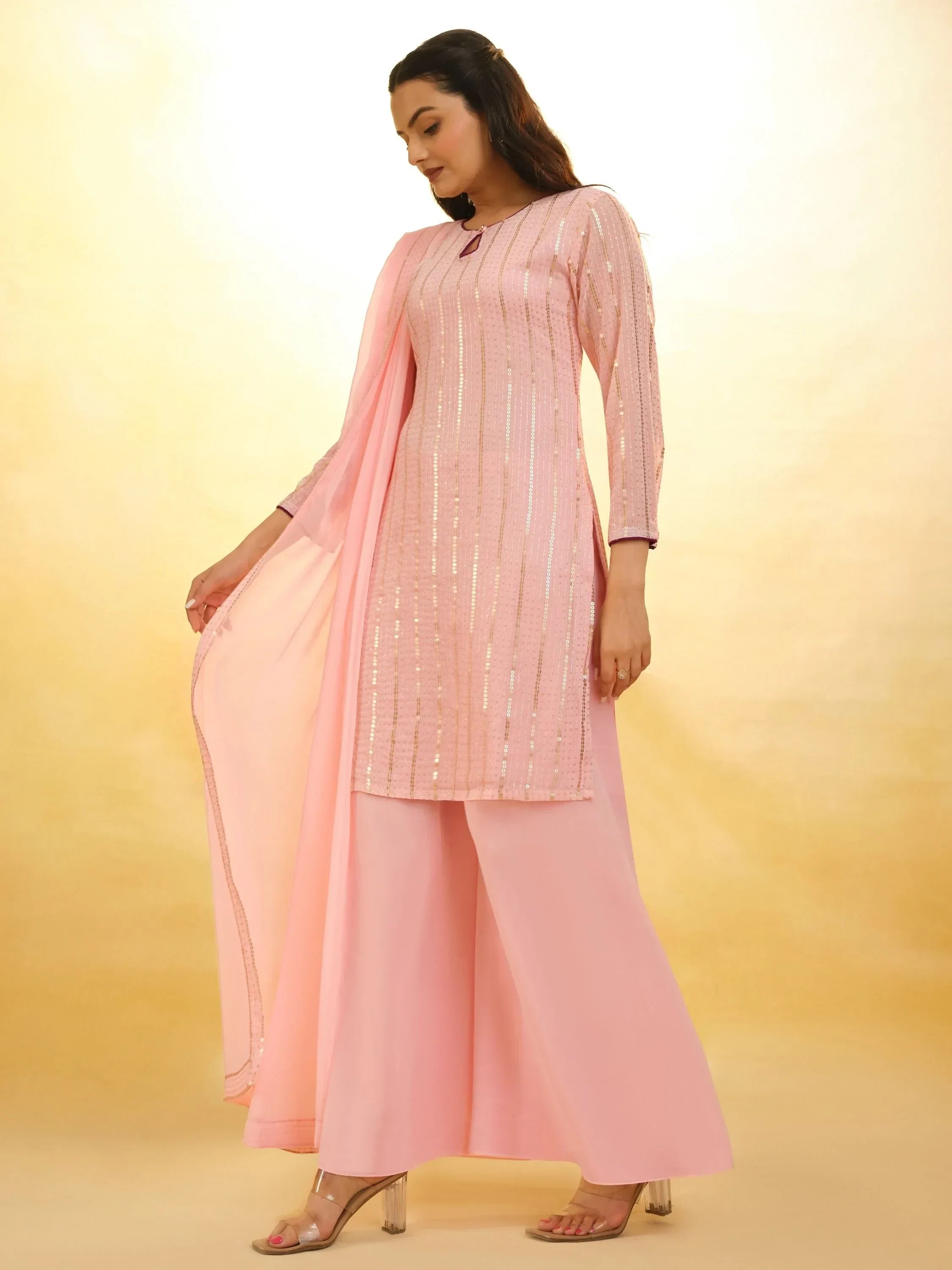 Woman in light pink ethnic palazzo suit with sequin detailing and matching dupatta
