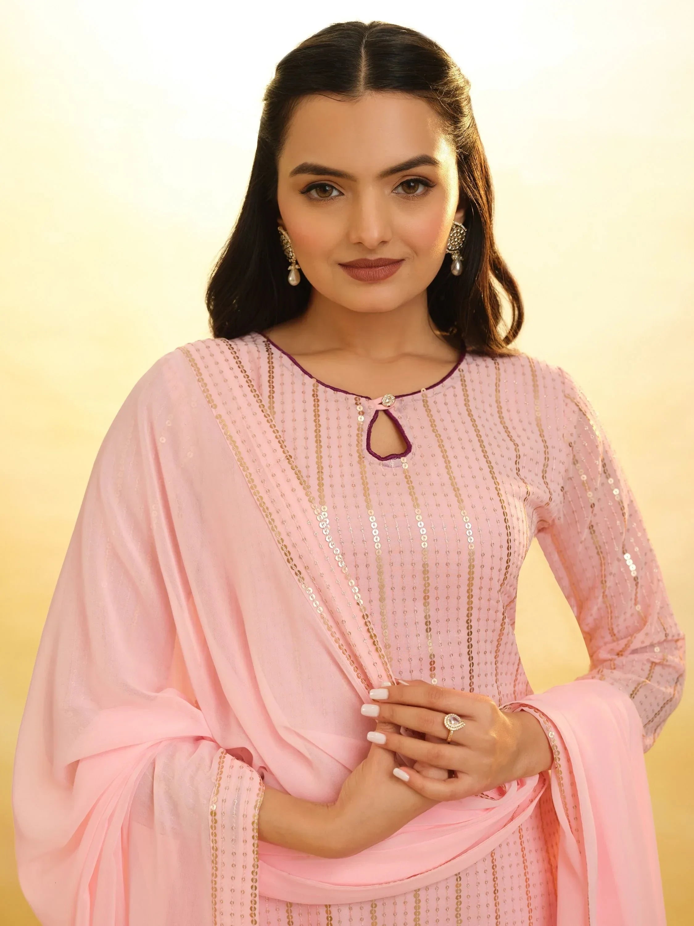 Woman wearing light pink embroidered salwar kameez and dupatta, ethnic Indian attire