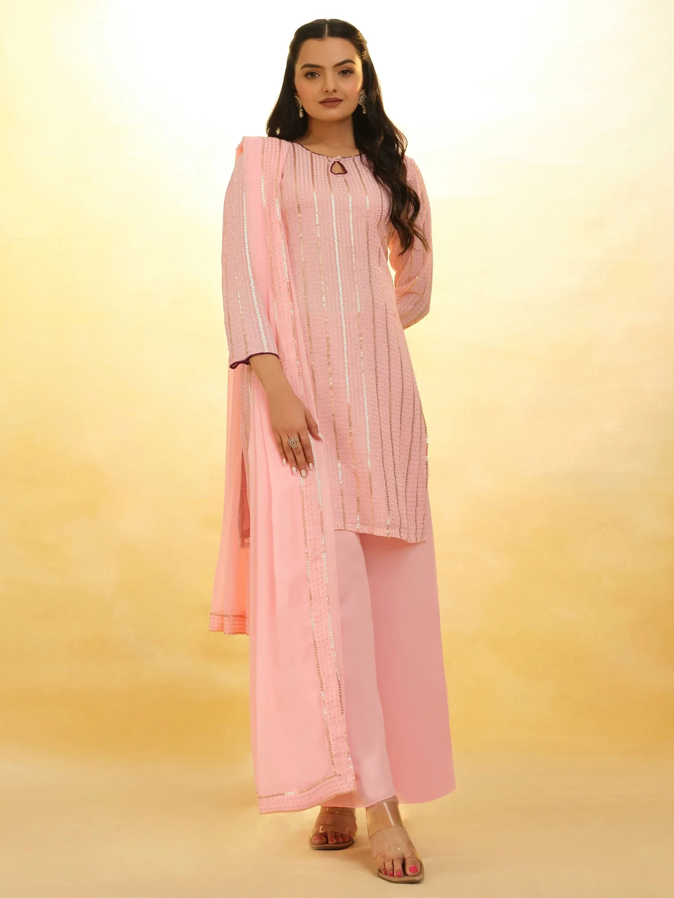 Woman wearing light pink Indian salwar kameez with dupatta and palazzo pants, front view