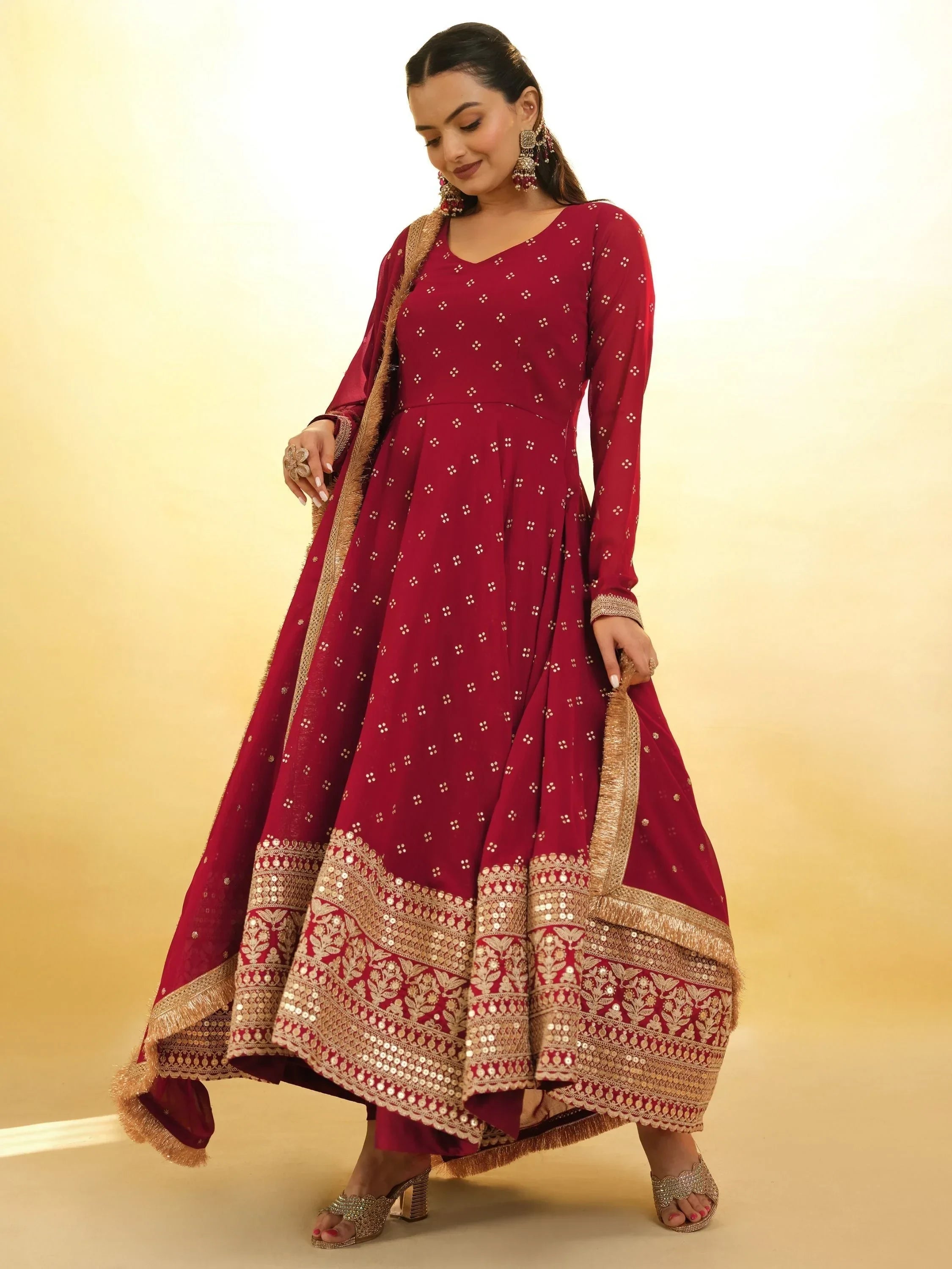 Woman in maroon ethnic Anarkali dress with gold embroidery and dupatta