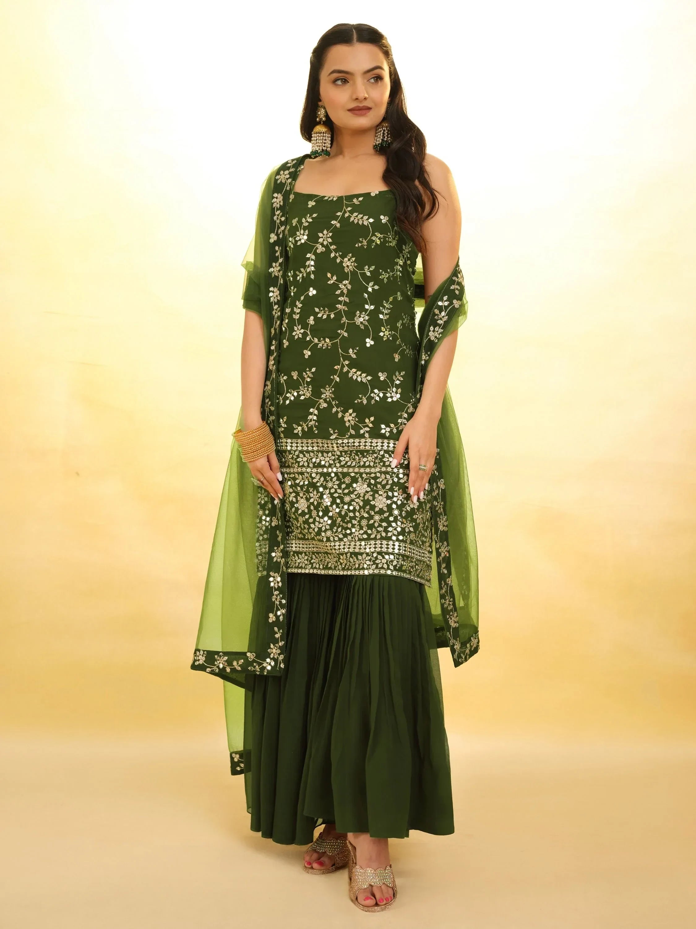 Woman wearing dark green embroidered Indian sharara suit with dupatta, festive ethnic wear