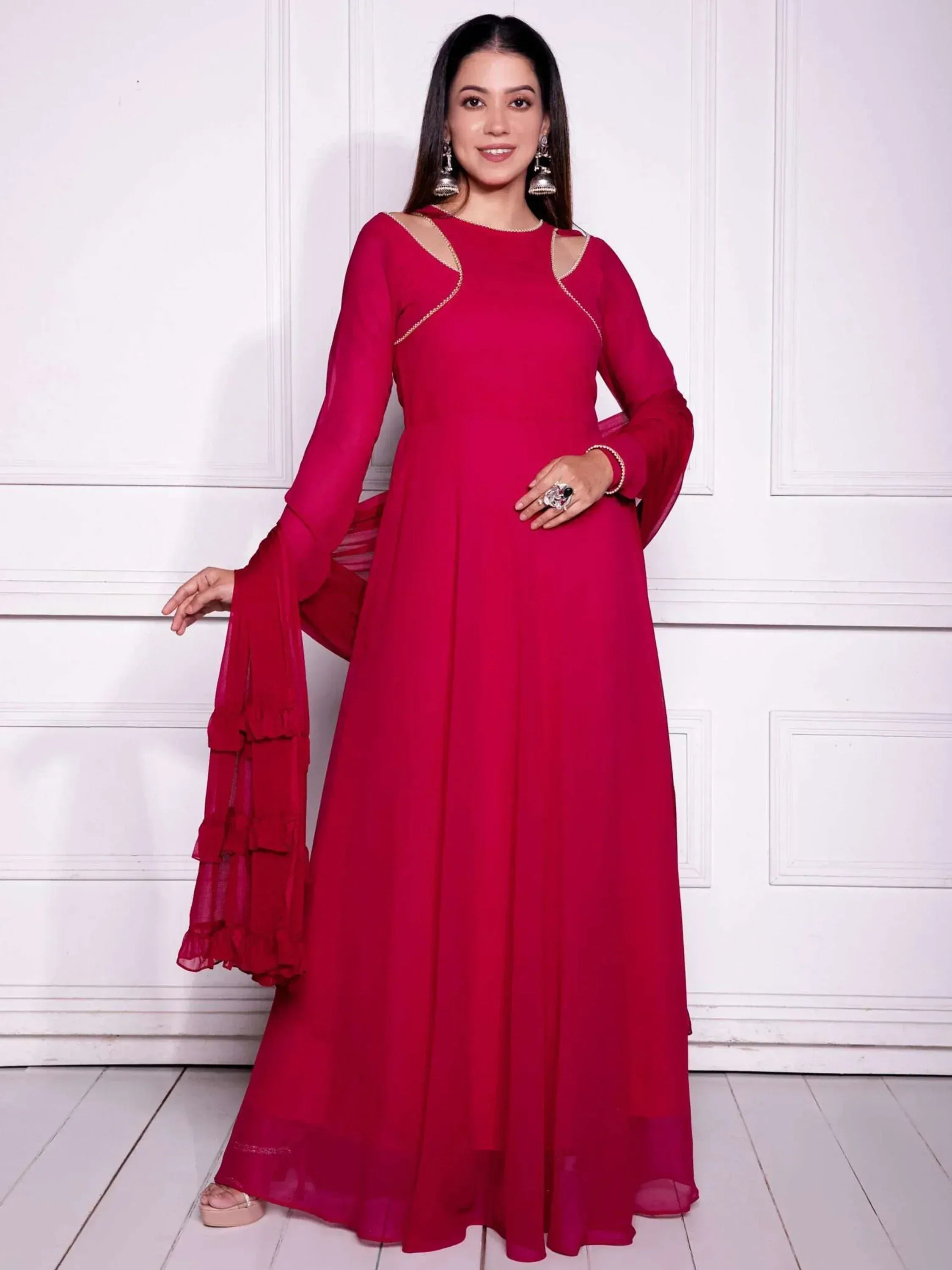 Woman in red ethnic gown with cut-out shoulders and ruffled dupatta, perfect for Indian occasions