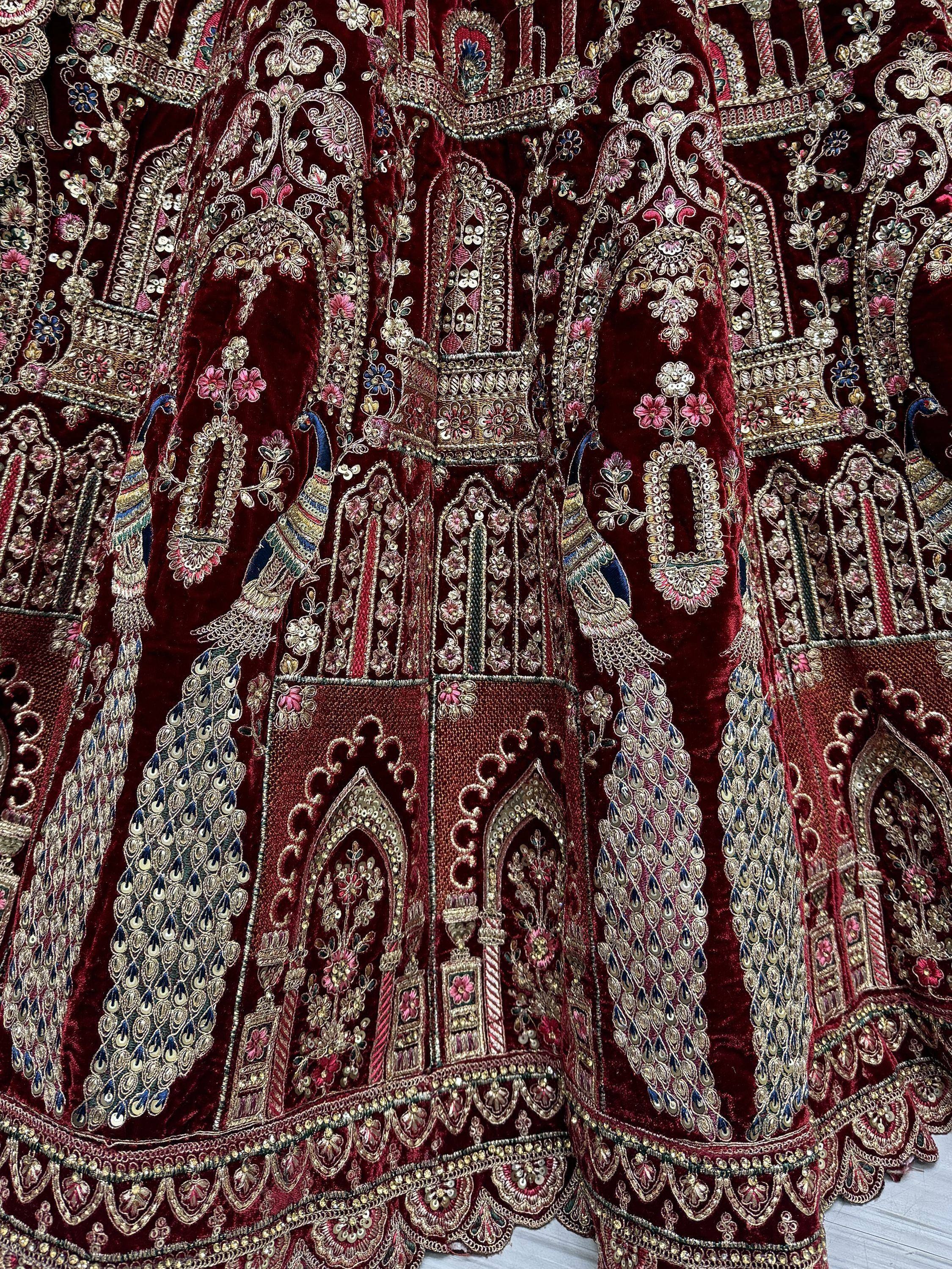 Rich maroon velvet lehenga with peacock embroidery and gold zari work, perfect for Indian weddings