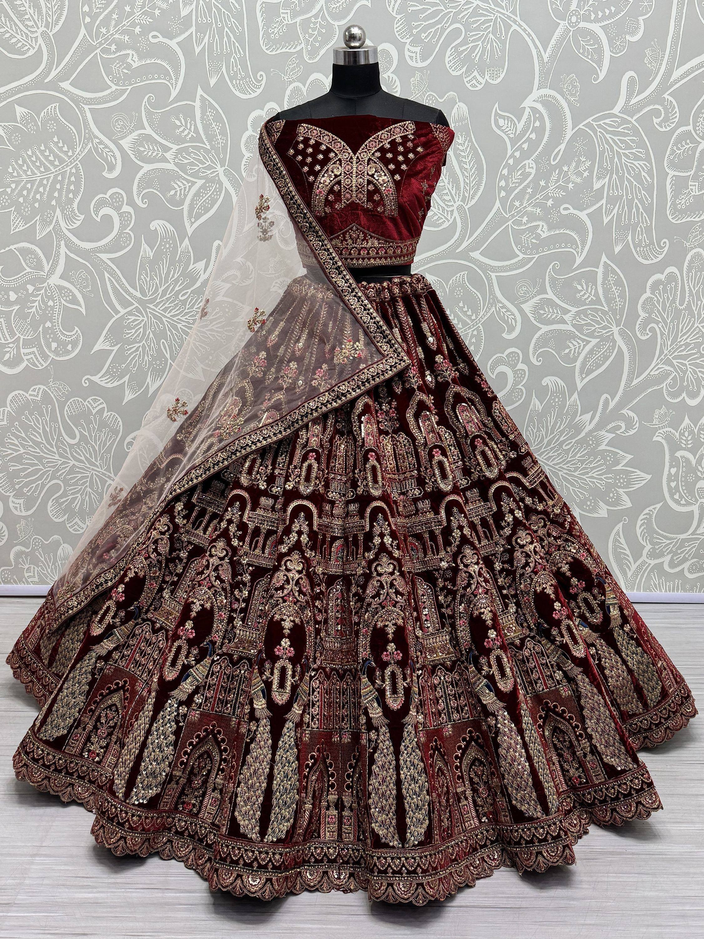 Maroon velvet designer lehenga choli with heavy gold embroidery and sheer dupatta, perfect for weddings