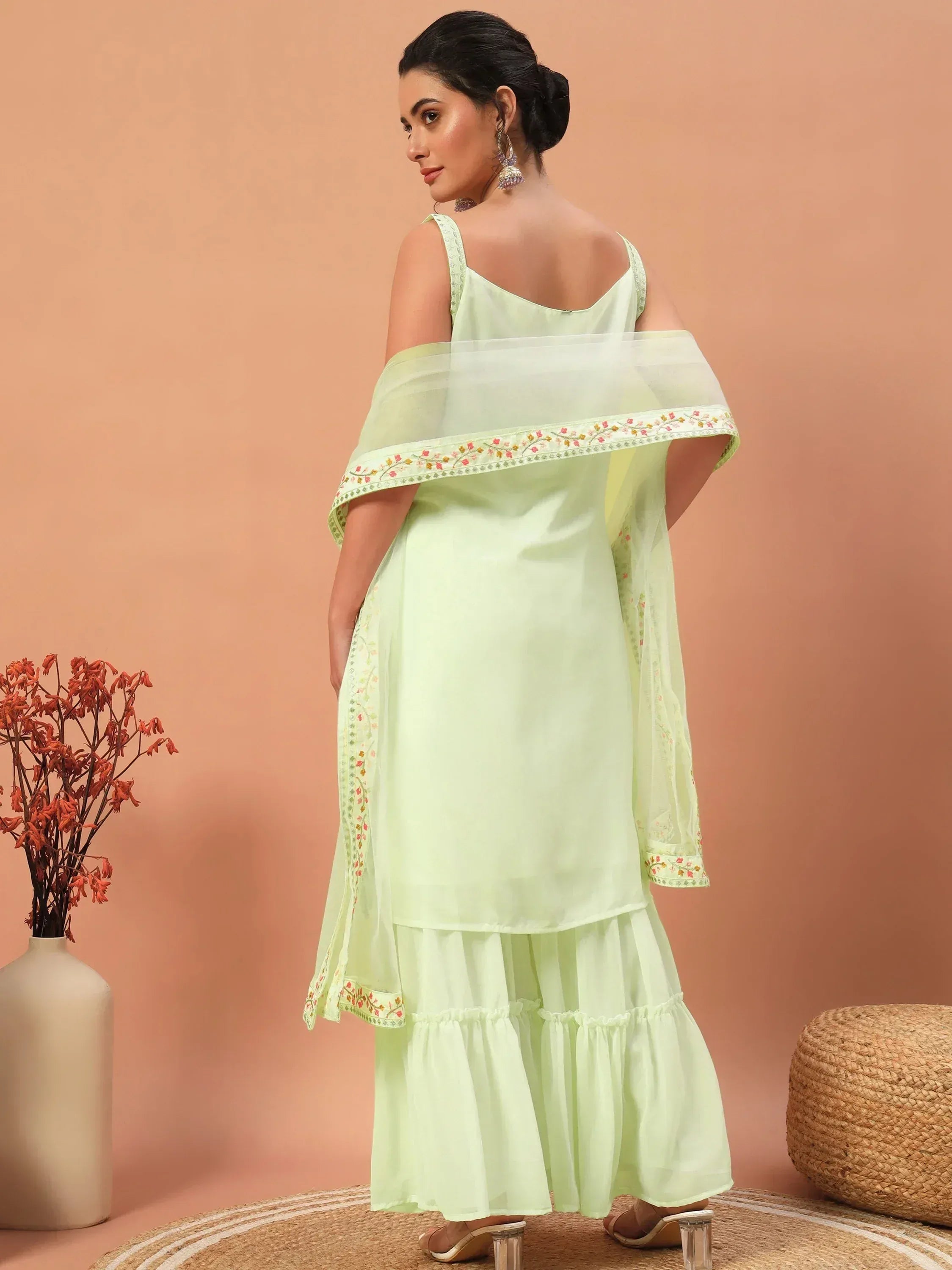 Light green embroidered ethnic gown with ruffled skirt and sheer dupatta, perfect for Indian occasions