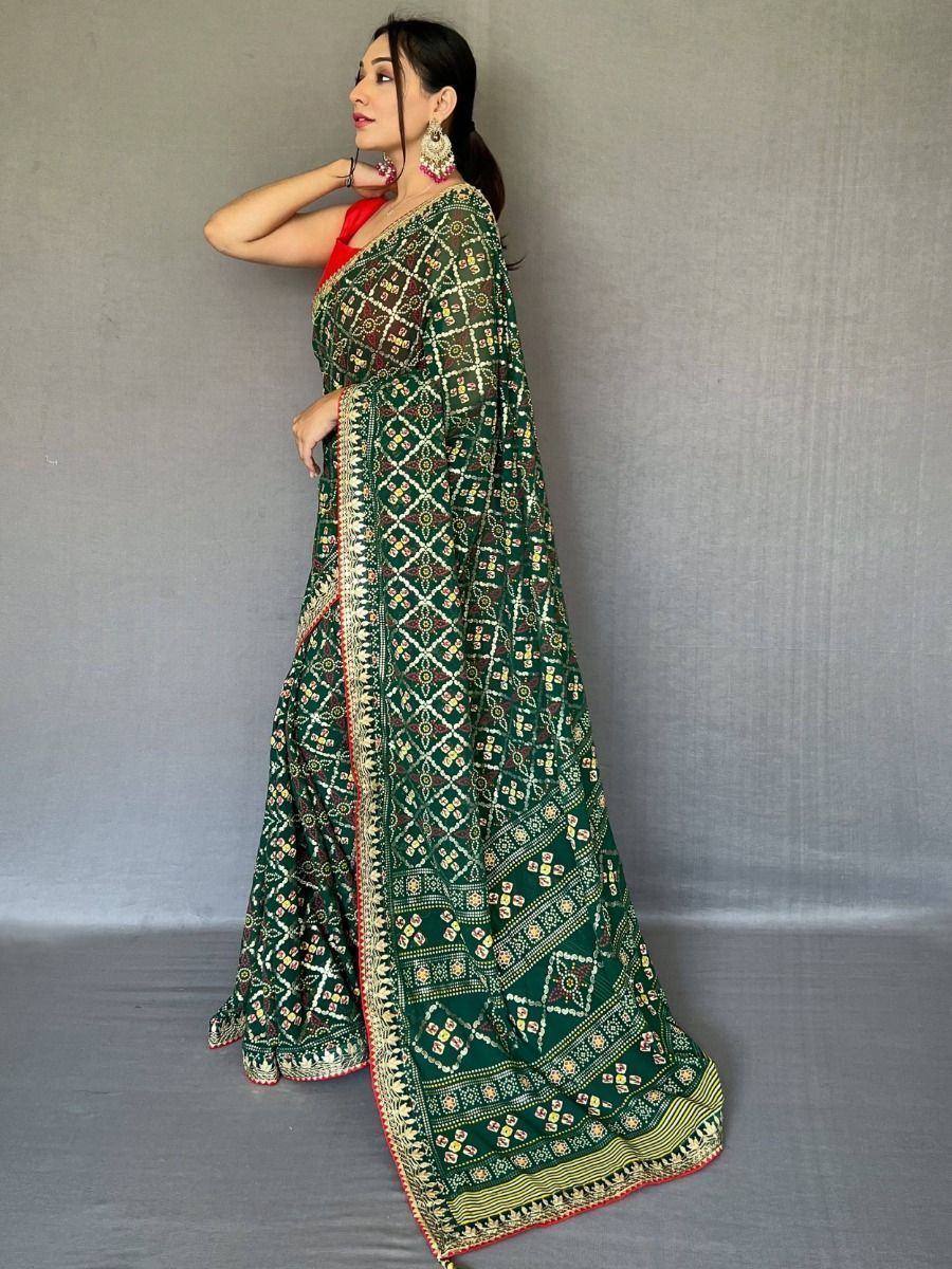 Green printed saree with geometric patterns, red blouse, and ethnic jewelry for Indian ethnic wear